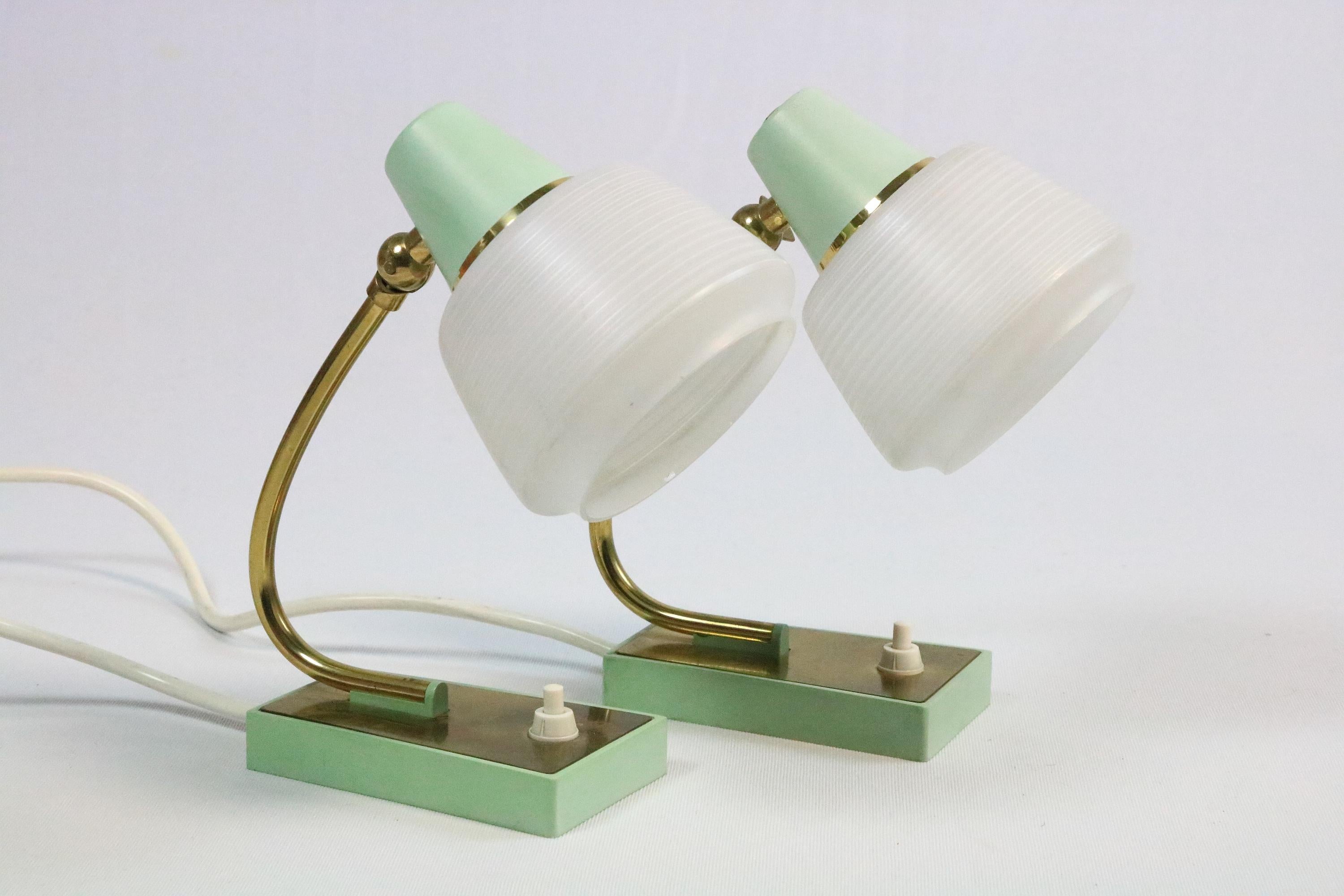 Deux jolis petits classiques des années 1950.
Lampes de chevet avec abat-jour en verre et cadre en métal vert menthe.
Détails du laiton.
 
L'un des verres présente deux très petits éclats sur le bord (voir photo), qui ne sont pas très visibles.
Le