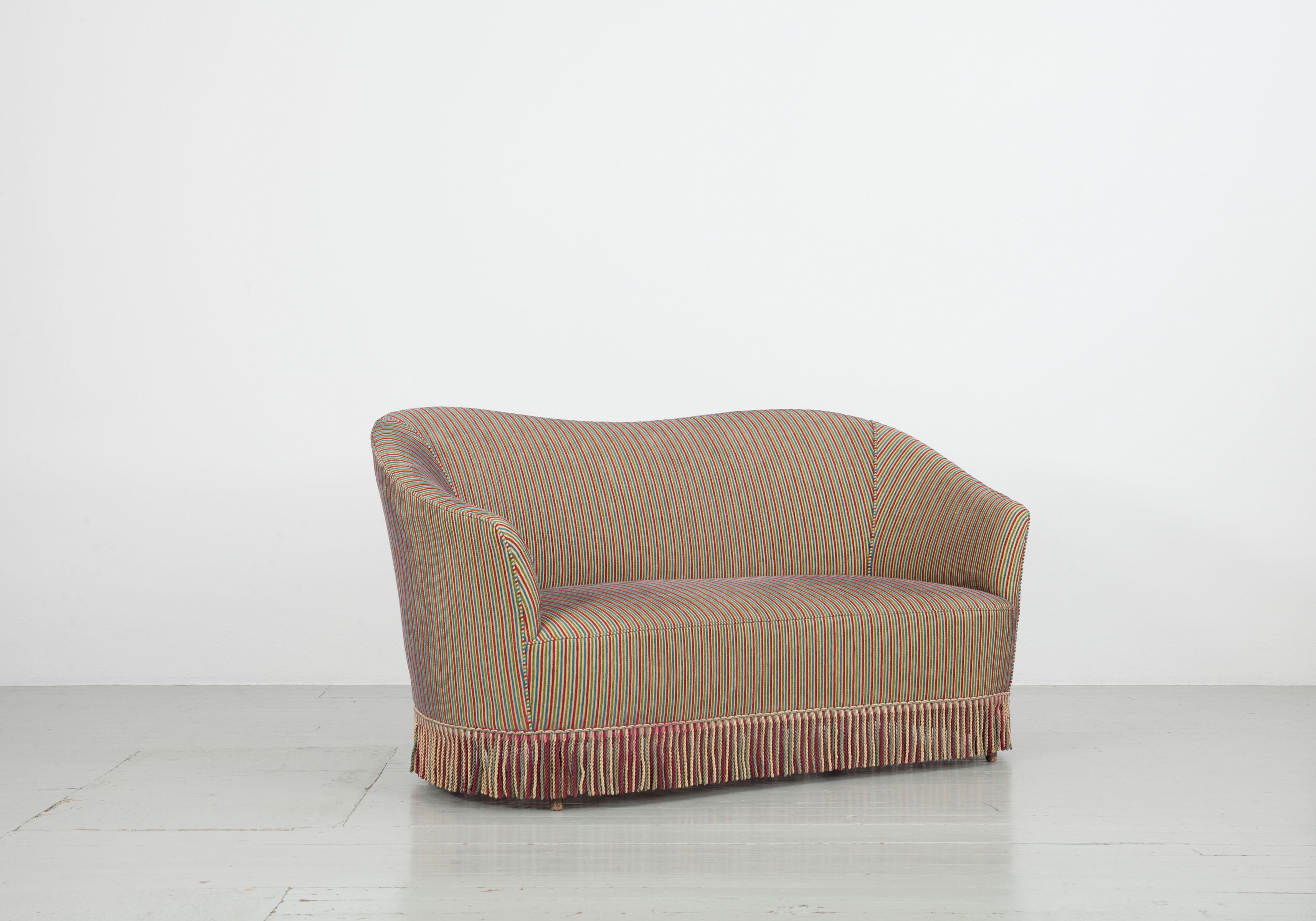 Cet ensemble de deux canapés a été conçu en Italie dans les années 1940 et 1950. Elle est recouverte d'un tissu de Fede Cheti. Les franges colorées cachent les pieds en bois et rendent le meuble individuel et extraordinaire. Les deux canapés sont en
