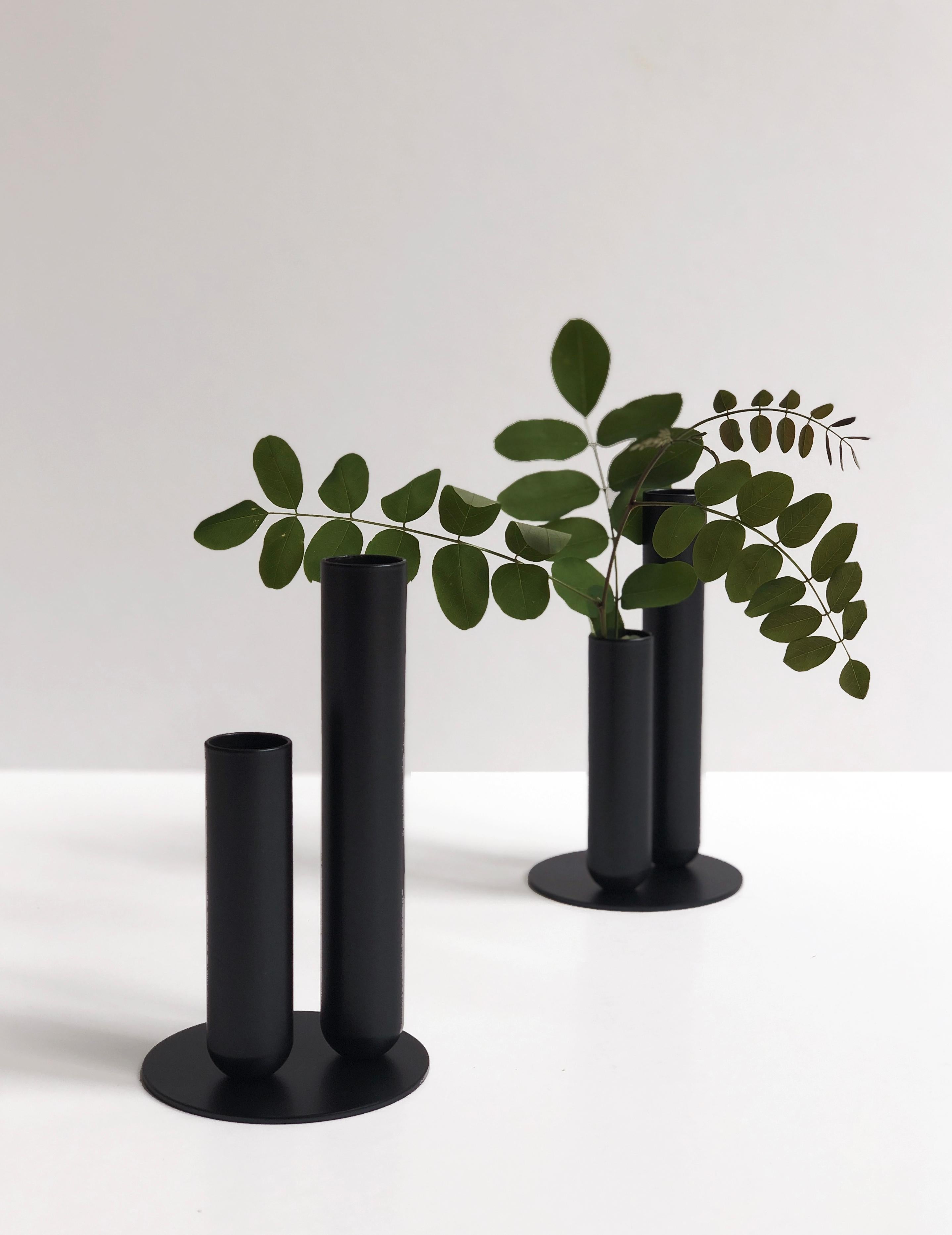 Set of 2 Soliflore Black Vases by Mademoiselle Jo
Dimensions: Ø 8.5 x H 15 cm (each).
Materials: Turned metal with magnet and EVA foam tray.

Hollow cylinders of 15 cm and 10 cm, diameter 2.5 cm. Plate diameter of 8.5 cm. Metal version with matt