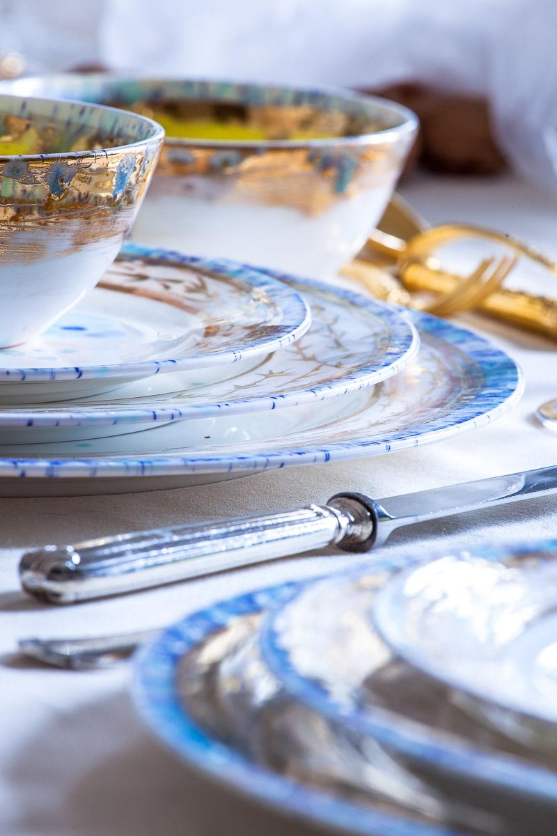 Hand painted in Italy from the finest porcelain, this Dafne soup coupe plate has a narrow pink and blue dotted rim surrounding a broad, delicate golden decor of stylised flowers; subtle light blue and pink brushes sprinkled with black powder float
