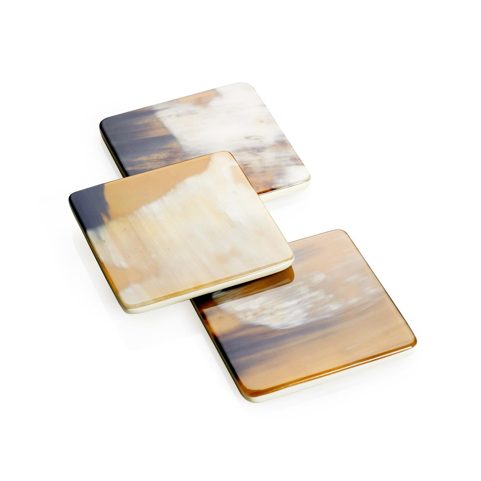 Featuring a simple yet elegant square shape, these coasters are entirely handcrafted from Corno Italiano and lacquered wood with cream-colored gloss finish. The striking natural veins of Corno Italiano lend a unique aesthetic to the design which