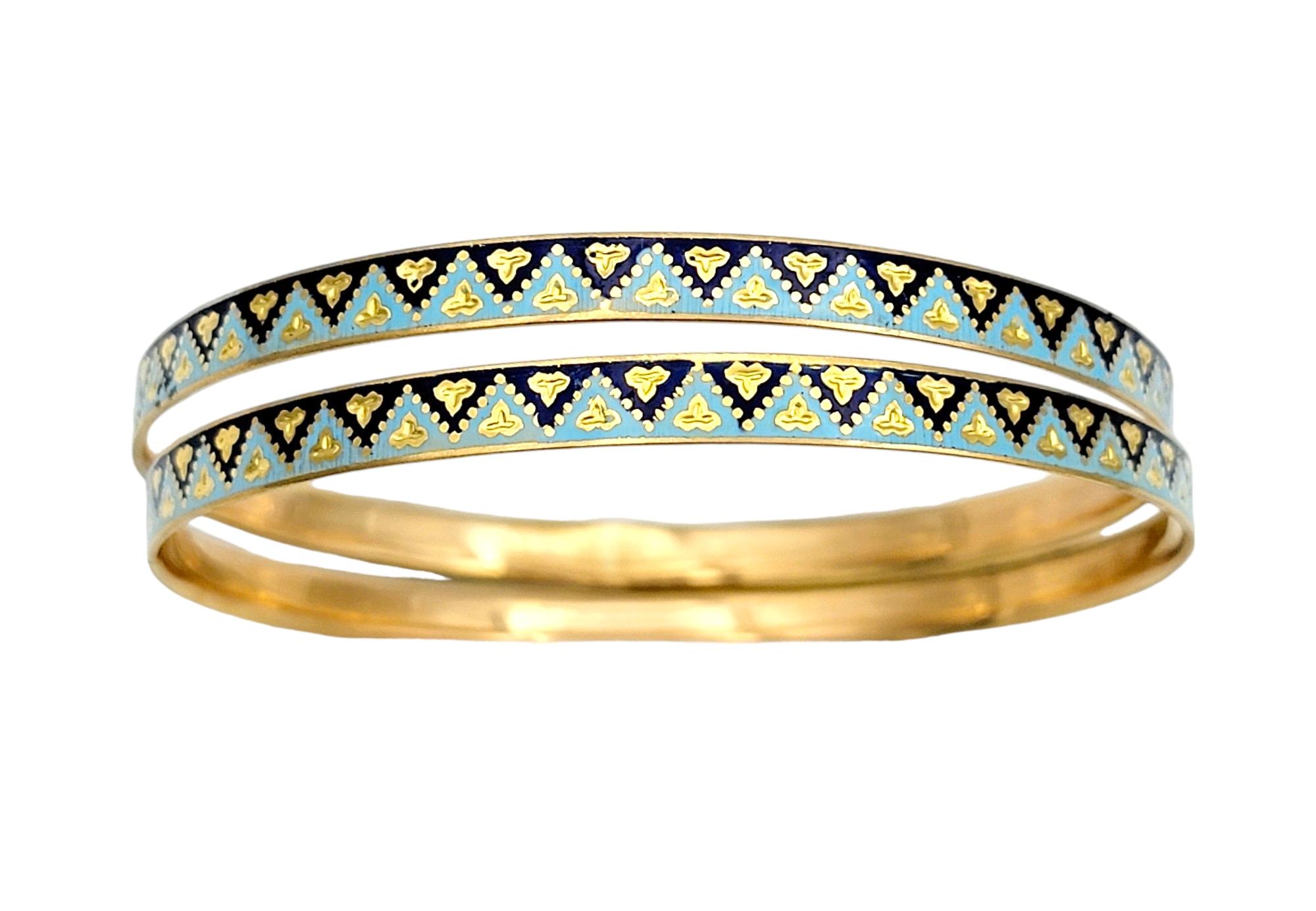 Introducing a luxurious set of two stacking bangle bracelets crafted in radiant 22 karat yellow gold, perfect for adding a touch of elegance to any ensemble. These identical pieces feature a mesmerizing zigzag design in alternating light blue and
