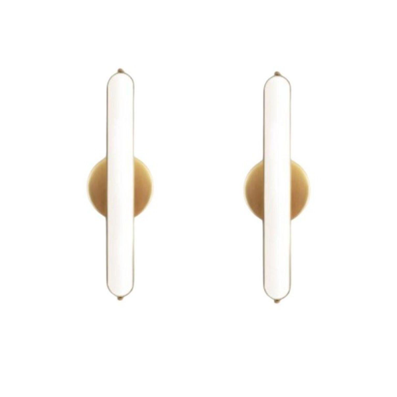 Set of 2 stadium round wall lights by Square in Circle
Dimensions: D 6 x W 11 x H 35 cm
Materials:Brushed brass/ white frosted glass
Other finishes available.

A long, rounded bathroom wall light with metal frame. The wall light is attached to a