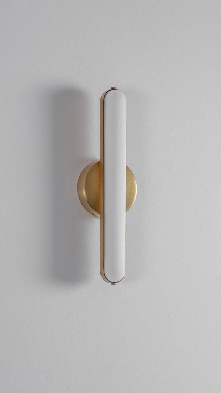 Set of 2 stadium round wall lights by Square in Circle
Dimensions: D 6 x W 11 x H 35 cm
Materials:Brushed brass/ white frosted glass
Other finishes available.

A long, rounded bathroom wall light with metal frame. The wall light is attached to a