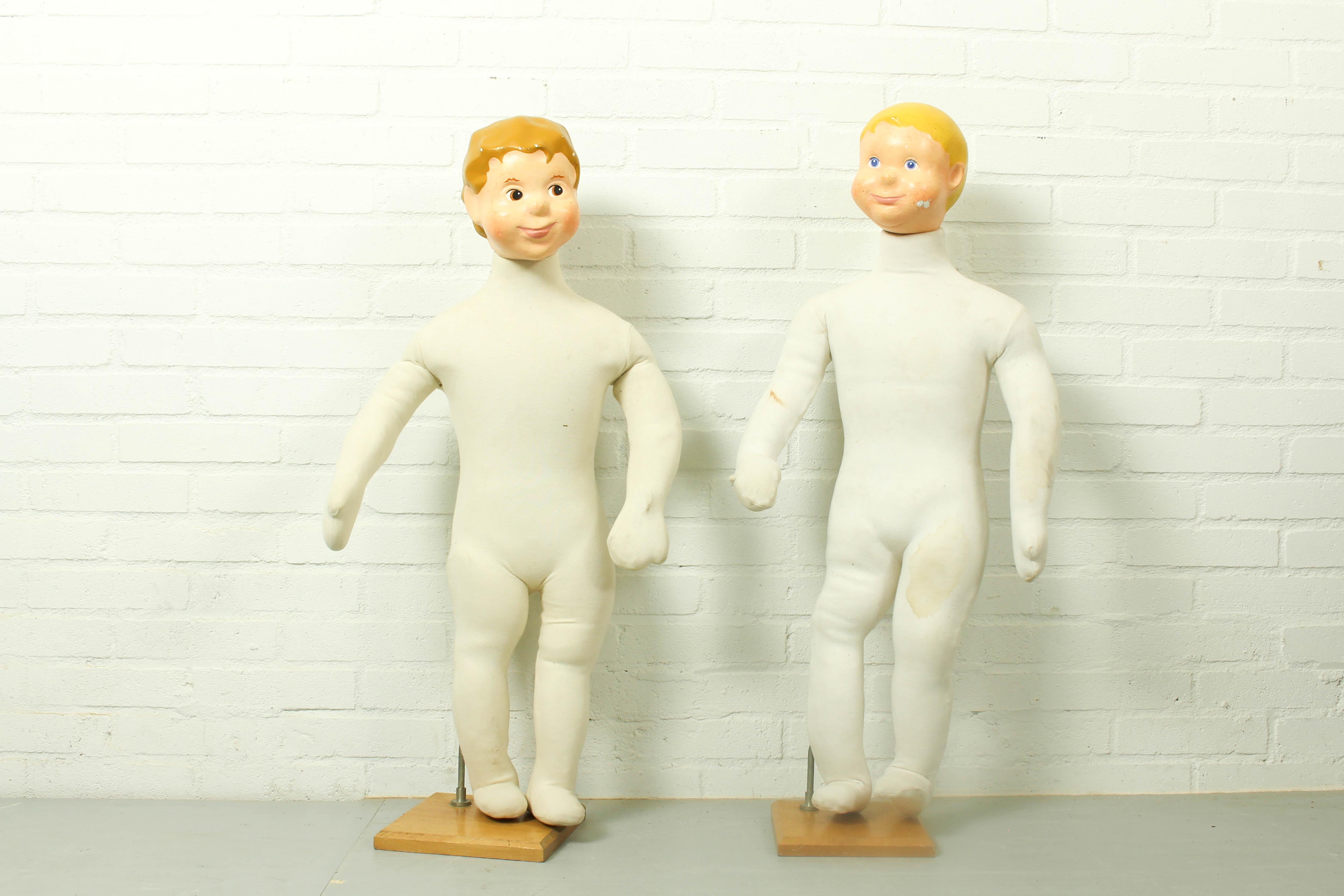 Mid century child mannequin doll. These vintage mannequins are both male children. They have a soft tissue body and beautiful fiberglass cartoon style heads. These store display advertising dolls were probably designed for a clothing line which was