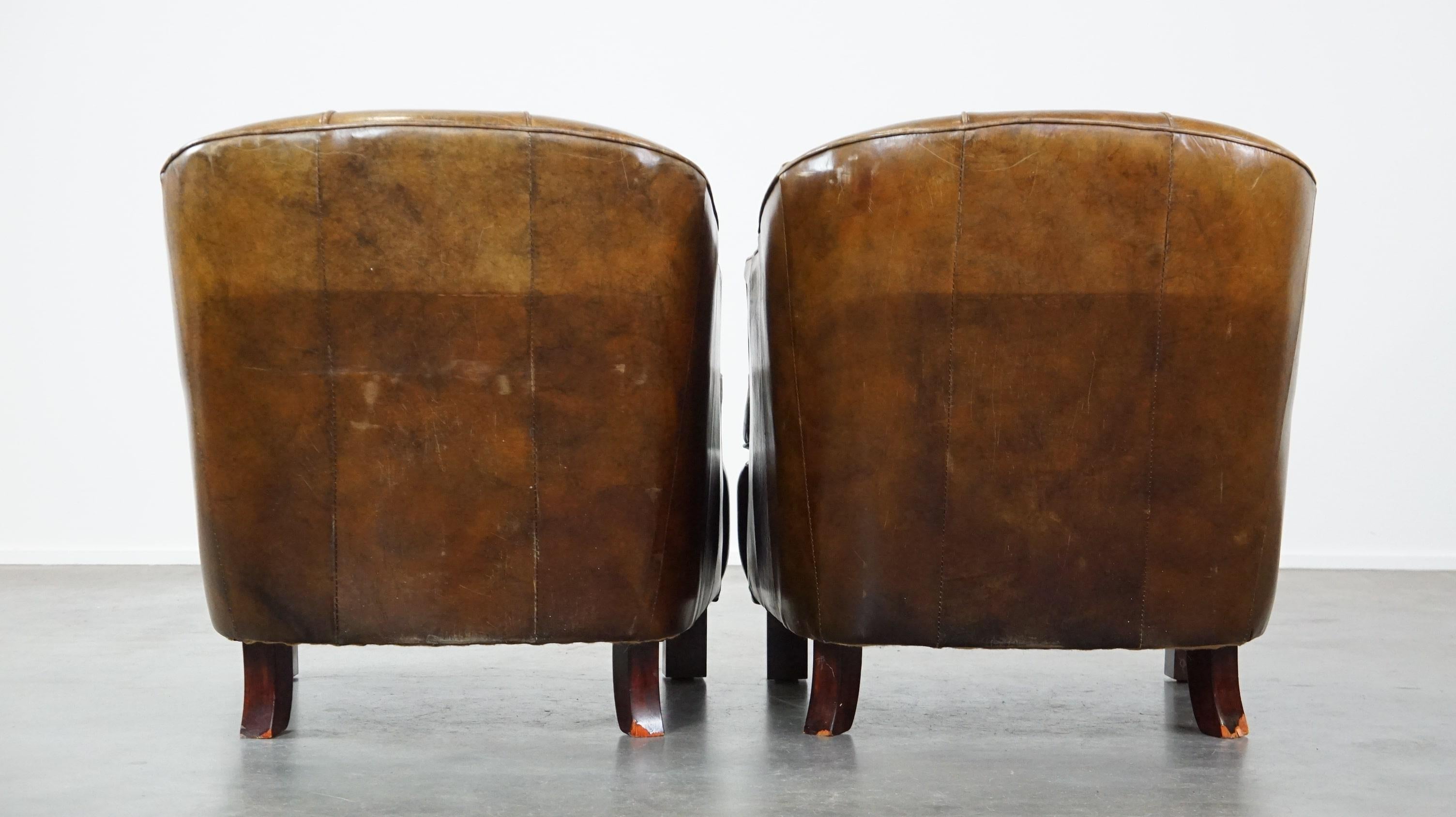 European Set of 2 sturdy design armchairs made of cowhide with a beautiful deep color For Sale
