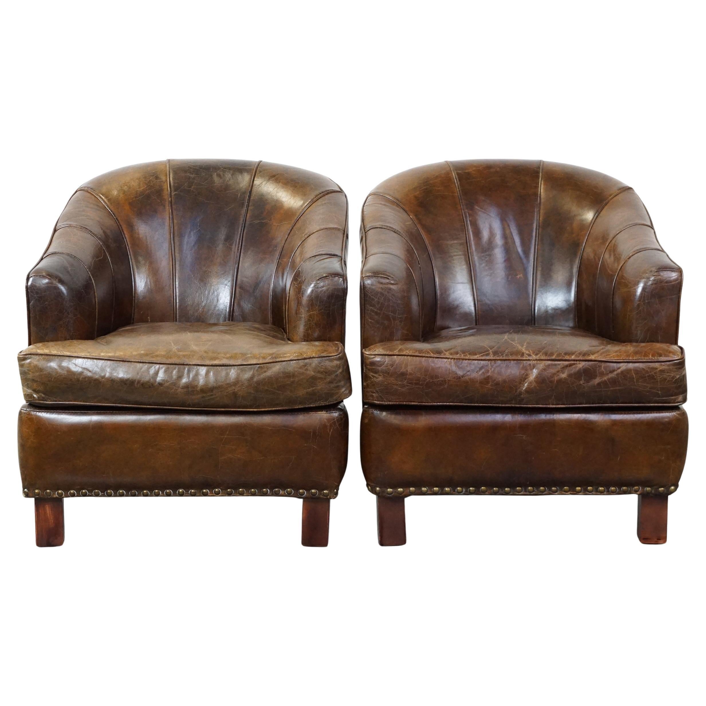 Set of 2 sturdy design armchairs made of cowhide with a beautiful deep color For Sale