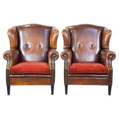 Set of 2 stylish vintage sheepskin armchairs with red corduroy seat cushions