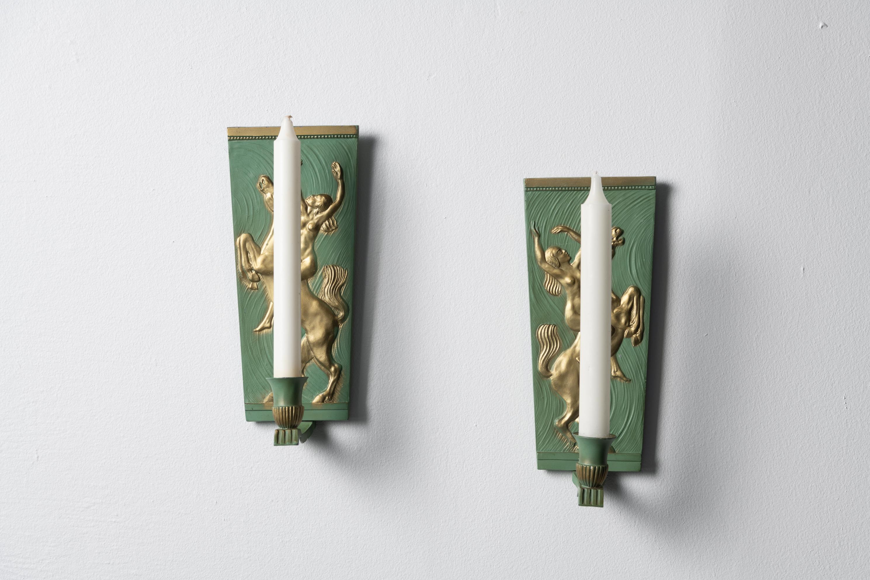 Swedish Art Deco wall lights, or sconces as they are also known, made by Stjärnmetall Ystad in Sweden. The sconces are from the early 20th century, around 1920 to 1930 and are made in a metal alloy. The pair of sconces have a unique imagery and