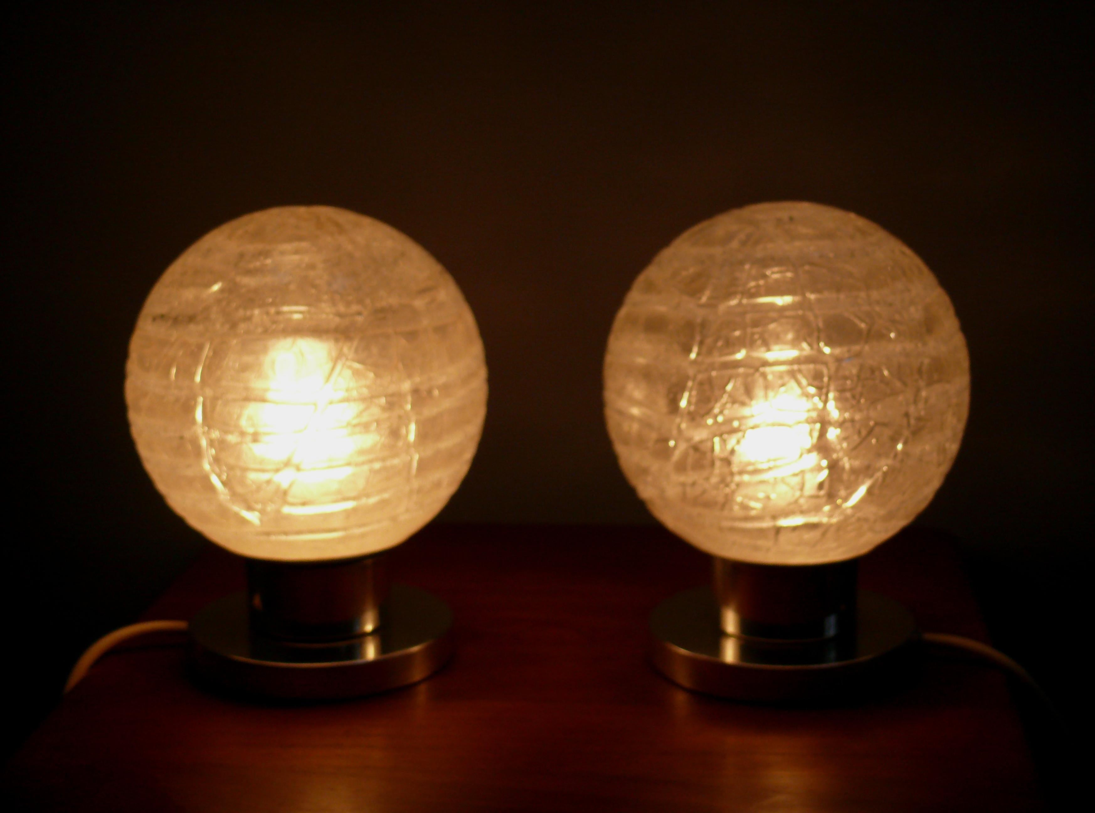 1 Paar Tischlampen mit Eisglaskugeln auf einem Chromsockel von Doria - Modell Nr. 1280, Westdeutschland. Die Lampe besticht durch ihr 70er-Jahre-Design, die solide Verarbeitung und den guten Originalzustand mit sehr schönen, gut erhaltenen Schirmen.