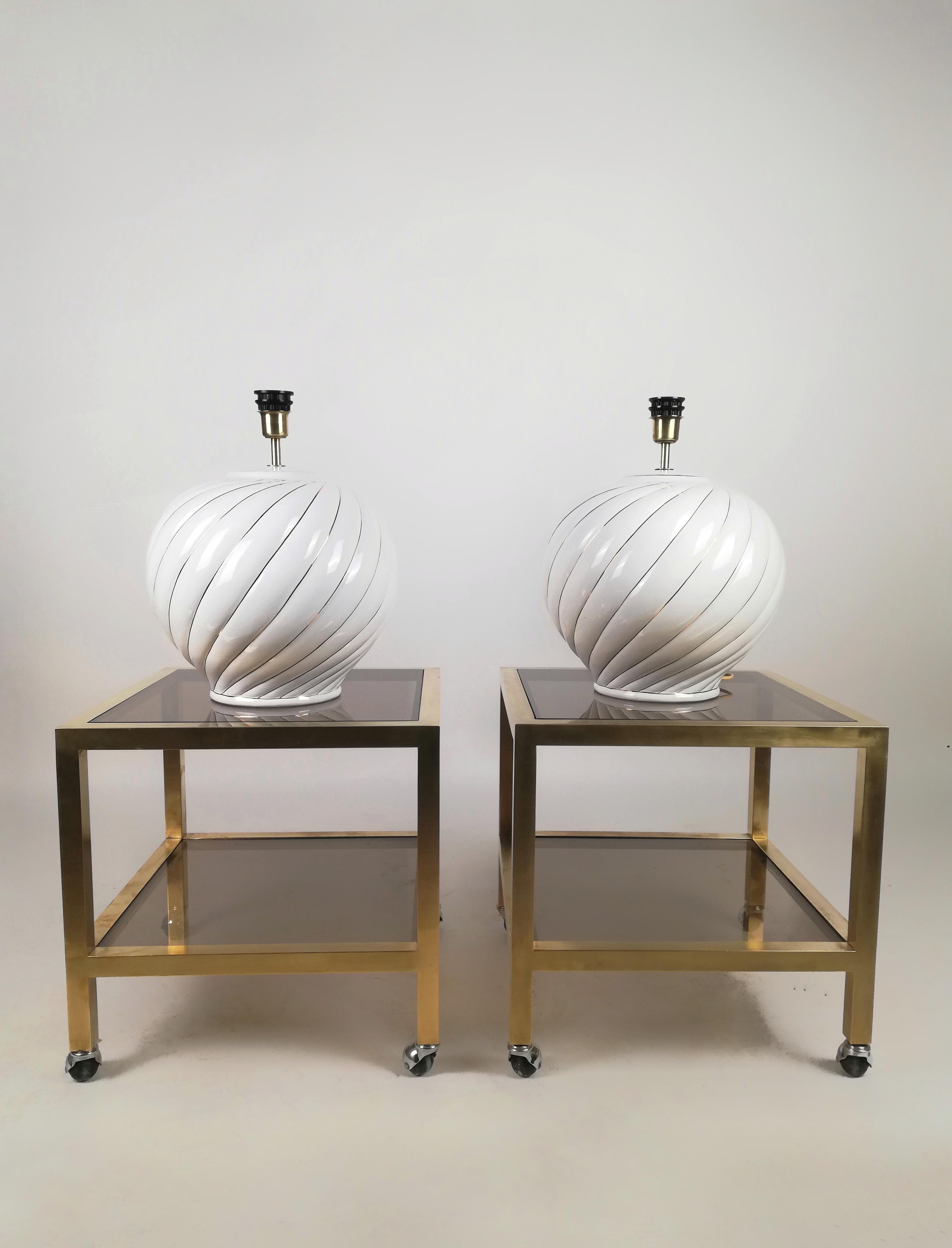 A Pair of 1970s lamps by Tommaso Barbi.
They were made in Italy in white glazed ceramic with gold details.
The 38cm diameter structure has a rounded and ribbed shape highlighted by gold brushstrokes.
The manufacturer's mark is visibile at the