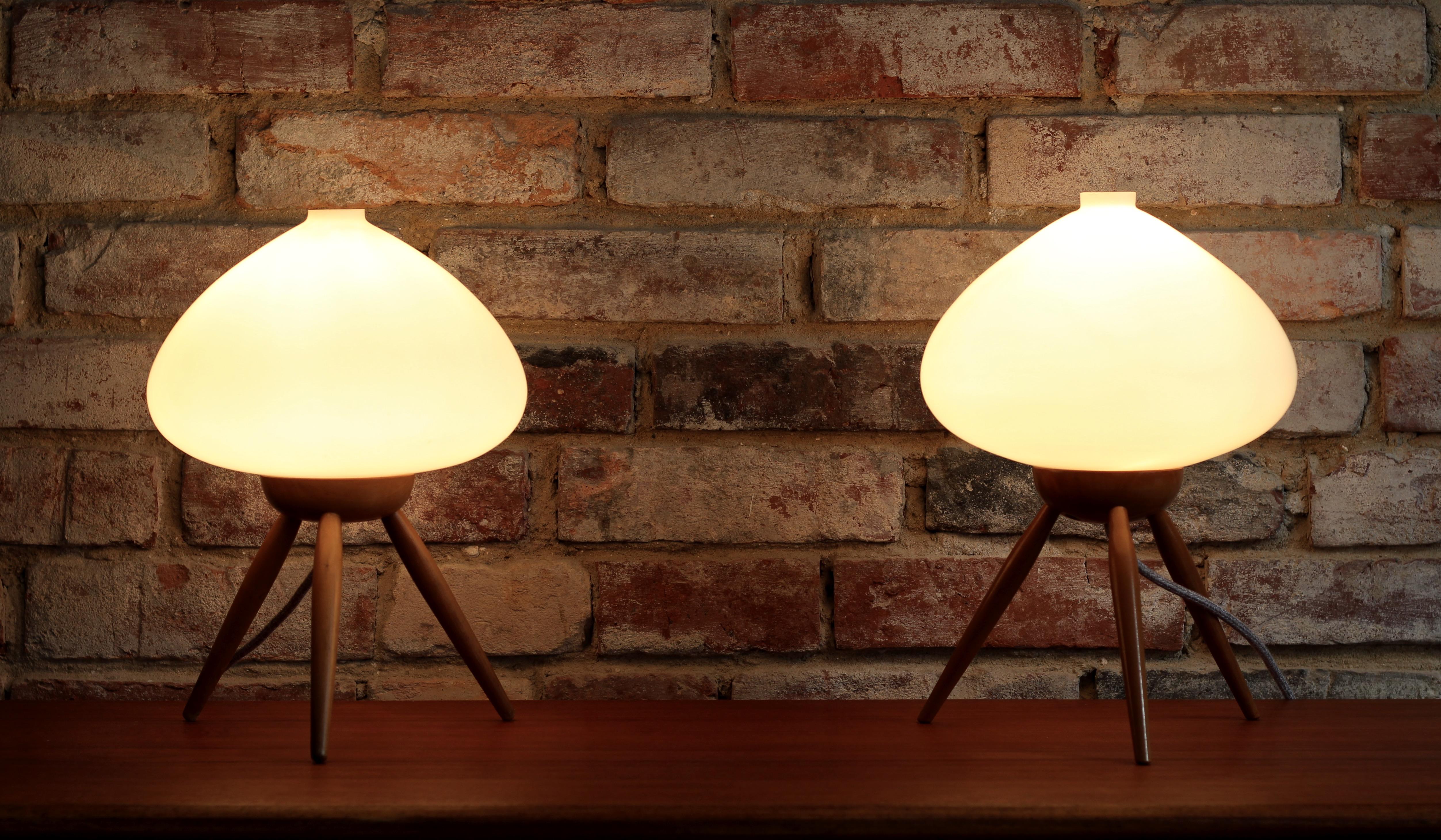 Extremely rare table lamps from Czechoslovakian company - ULUV (Ustredi lidove a umelecke vyroby) from 1960s. The lamps have beautifully shaped milk-white opaline glass lampshades set on a tripod wooden bases. They give warm delicate light creating