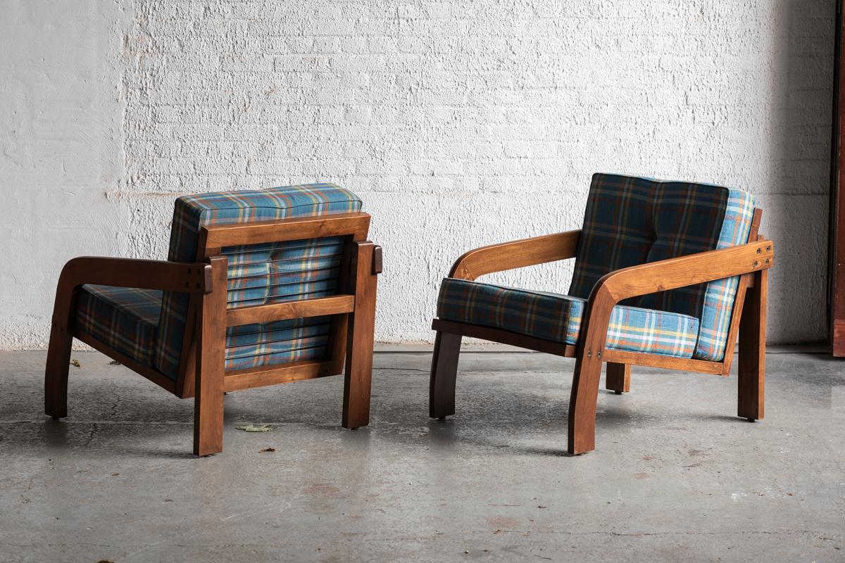 Set of 2 modernist easy chairs designed and produced in Italy during the 1950s. These dark stained wooden frames are complemented with the original tartan pattern pillows. Imported straight from Italy. Pillows show a bit of pilling but further this