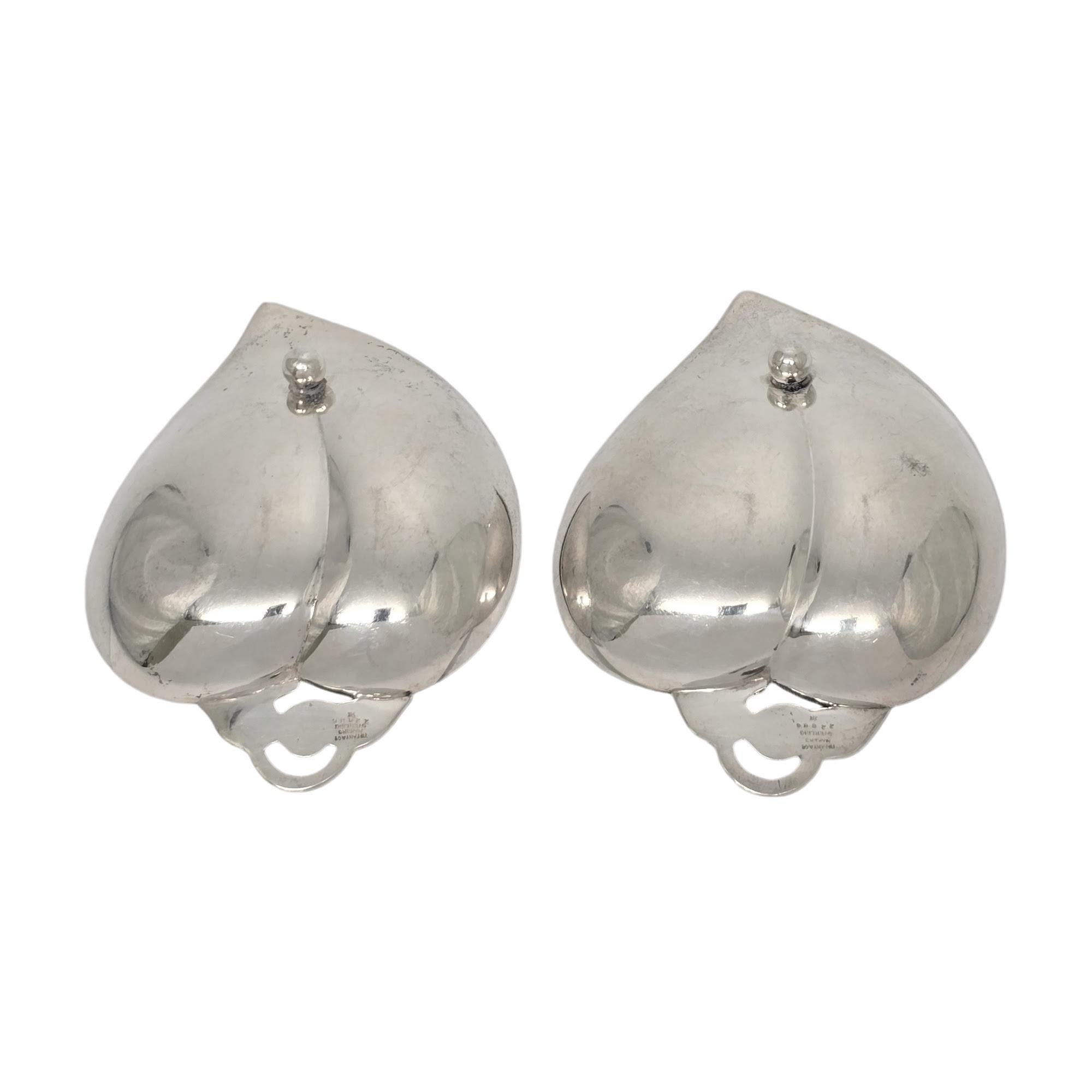 Set of 2 sterling silver heart or apple shaped dishes/bowls by Tiffany & Co.

A pair of small dishes in the shape of an apple or heart with openwork scroll leaf and 1 ball foot underneath. Hallmarks date these pieces to manufacture under the