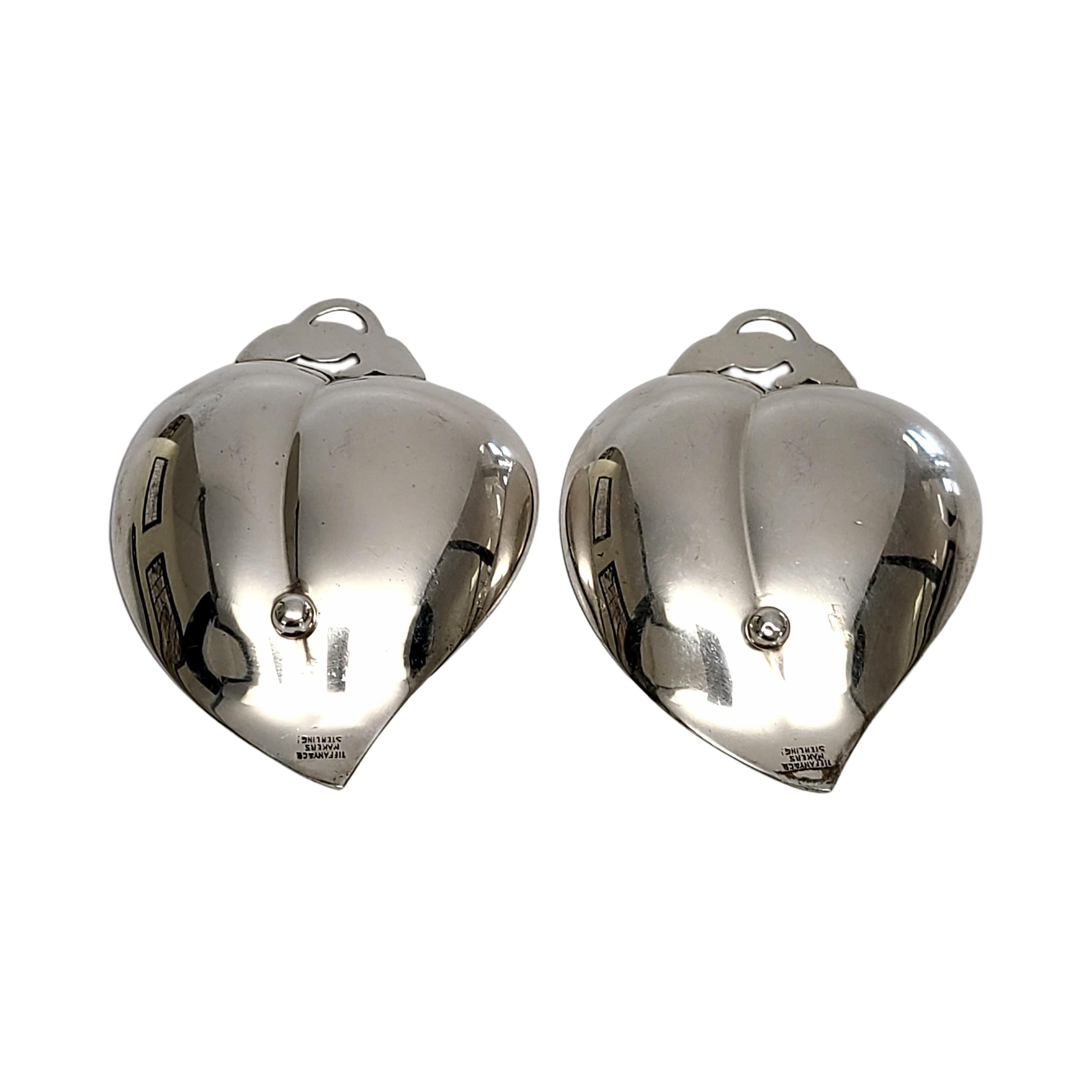 Set of 2 Tiffany & Co sterling silver small heart/apple shaped dishes.

A pair of small dishes in the shape of an apple or heart with openwork scroll leaf and 1 ball foot underneath. Does not include Tiffany & Co box or pouch.

Each dish measures