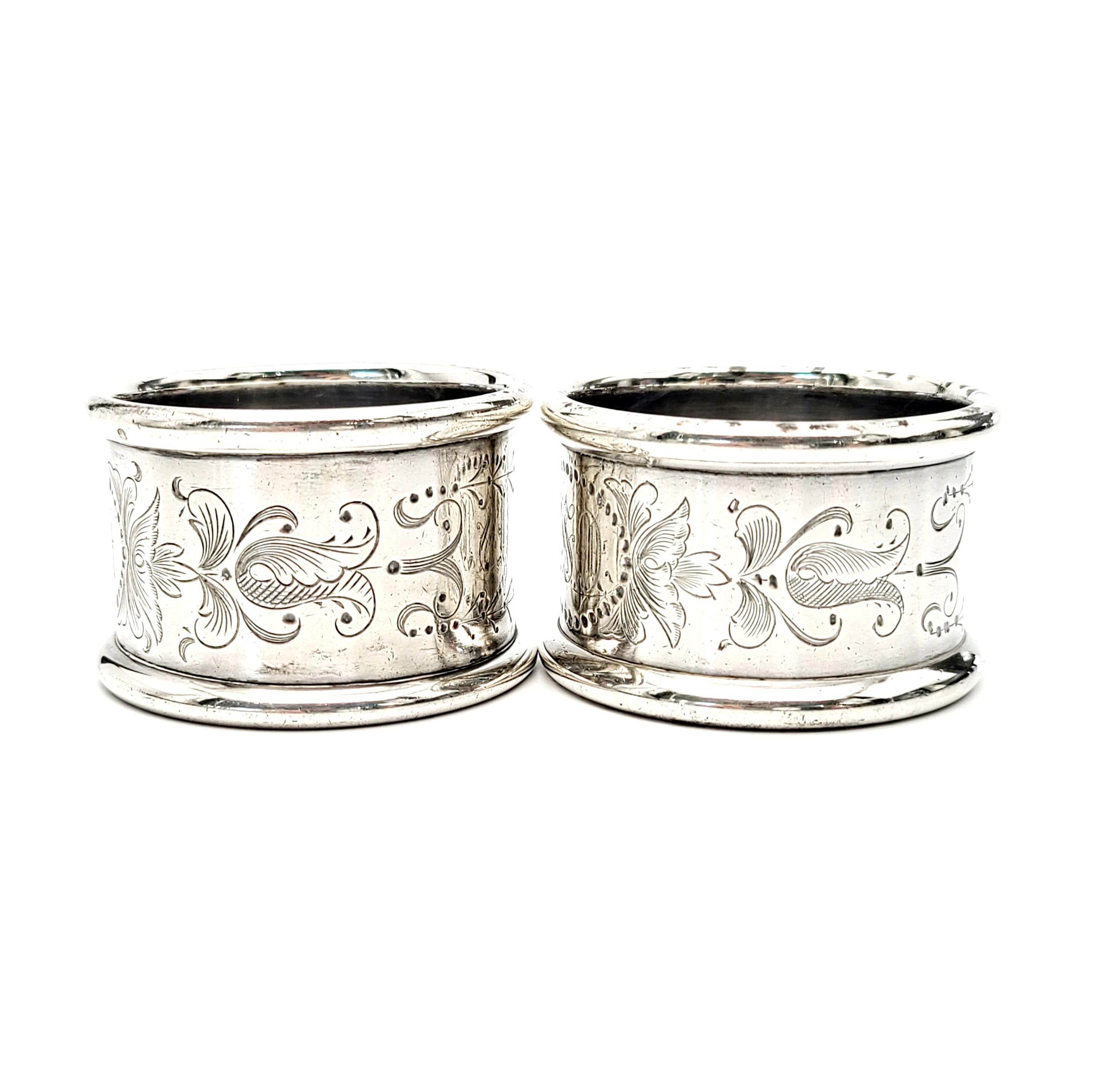 Set of 2 sterling silver napkin rings by Towle.

Etched scroll and leaf design all around each ring. Monogram inside a dotted oval on each ring.

On one ring, monogram on the outside appears to be a EAI, inside monogram appears to be ASJ. On the