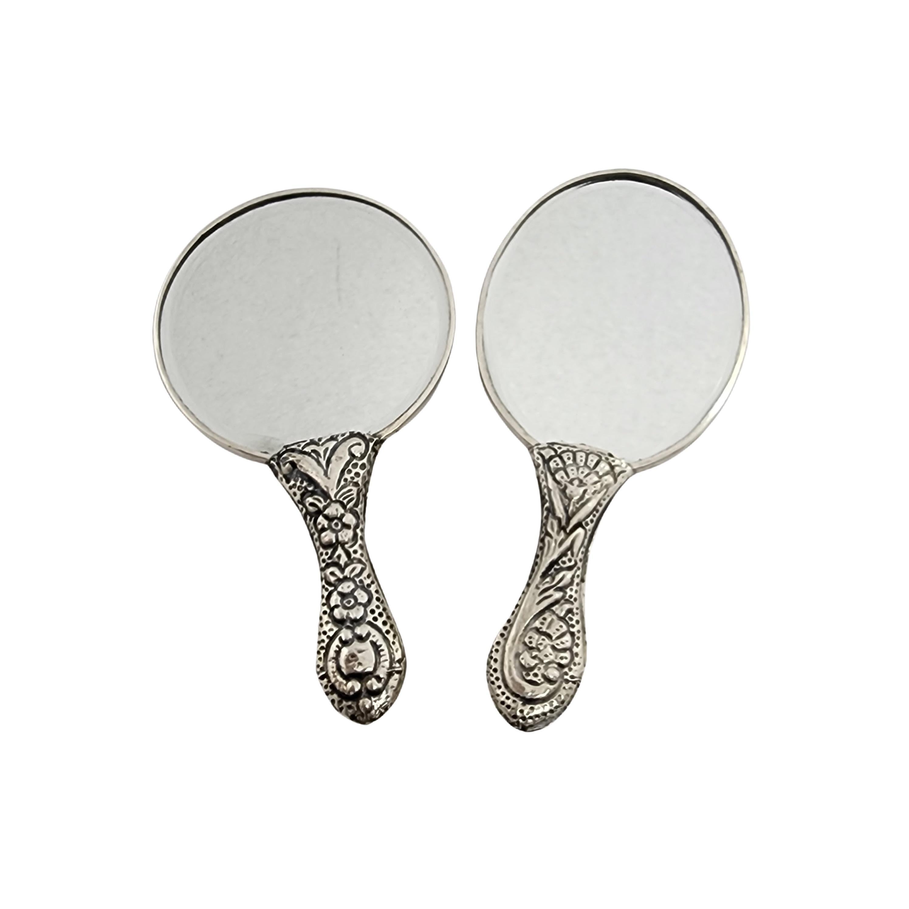 Set of 2 900 silver repousse hand mirrors by Turan of Turkey.

2 small hand mirrors in a floral repousse design. One features a round mirror, the other features an oval mirror.

Oval hand mirror measures approx 5 1/8