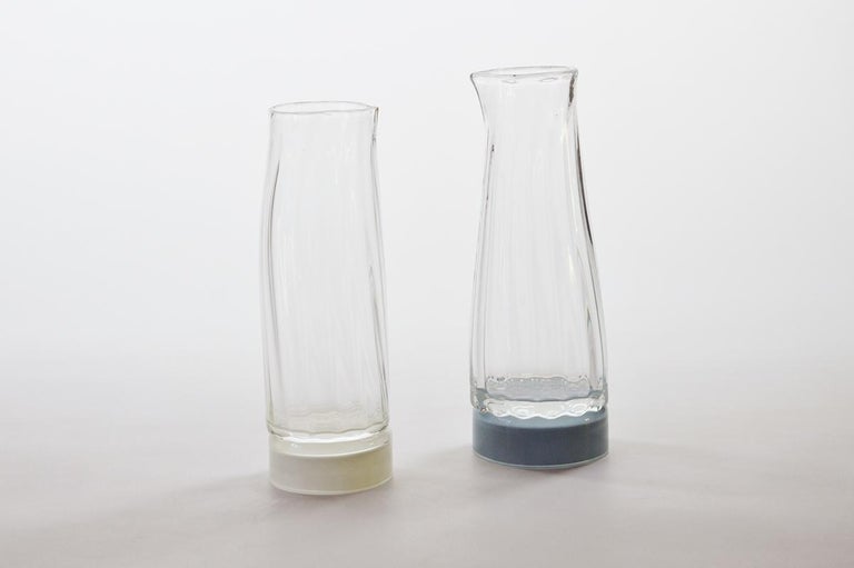 Set of 2 unique glass carafe by Atelier George
One of a Kind
Dimensions: Ø 80 x H 22 cm 
Materials: Handblown glass

Variation of colours available. 

The Moire collection is the result of a work on optical and transparency effects. It is