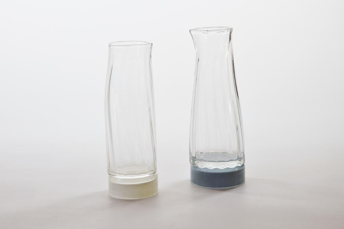 Set of 2 unique glass carafe by Atelier George
One of a Kind
Dimensions: Ø 80 x H 22 cm 
Materials: Handblown glass

Variation of colours available. 

The Moire collection is the result of a work on optical and transparency effects. It is named