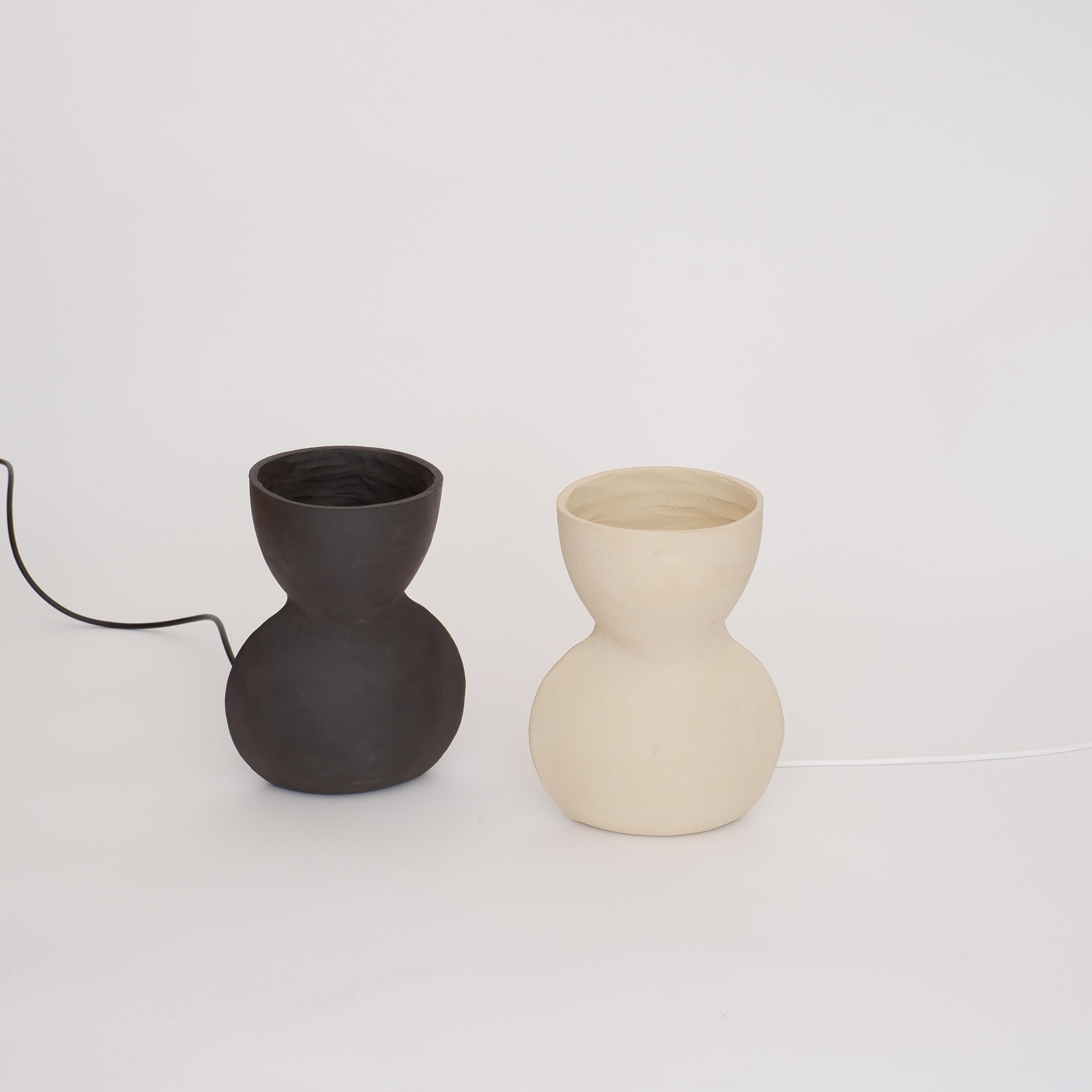 Set Of 2 Unira Small Black And White Lamps by Ia Kutateladze
Unique en son genre.
Dimensions : D 14 x L 18 x H 25 cm.
Matériaux : Argile.

Chaque pièce est unique, grâce au processus de construction à la main. Différentes variations de couleurs