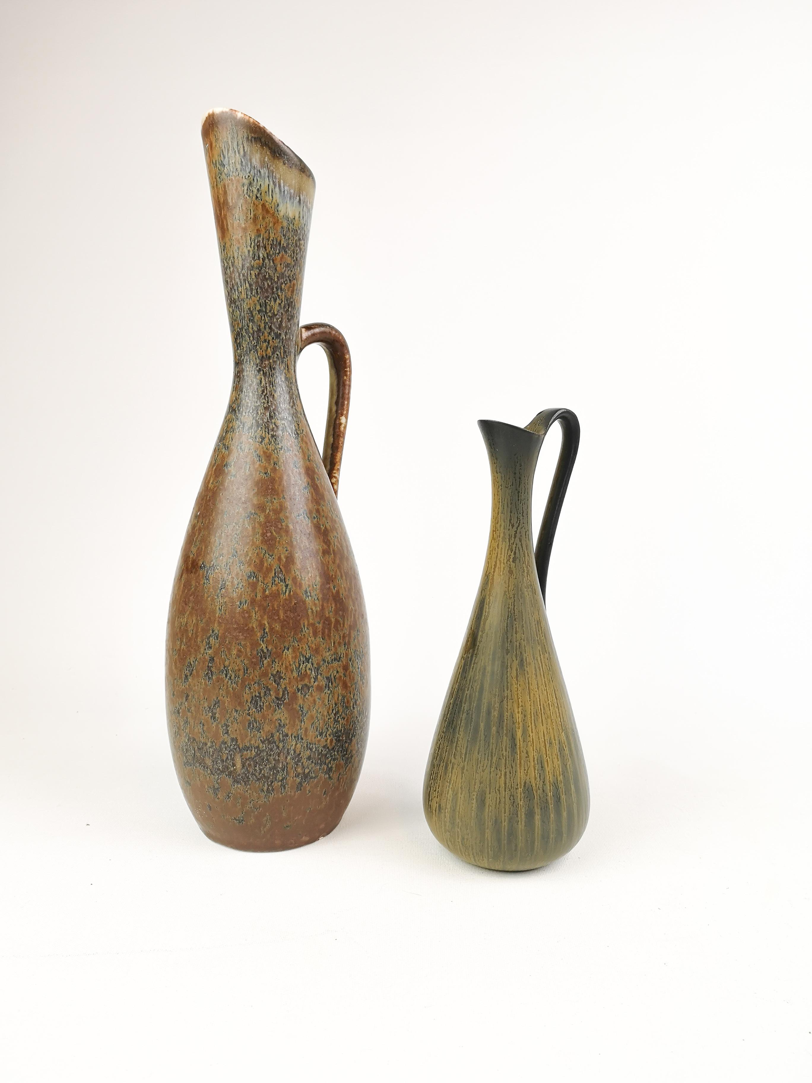 These two vases are made at Rörstrand Factory Sweden and was designed by Gunnar Nylund (the small) and his apprentice Carl-Harry Stålhane(the big). 
They are both beautiful in the sculpture and the glaze. 

Measures. The big H 33 cm D 12 cm the