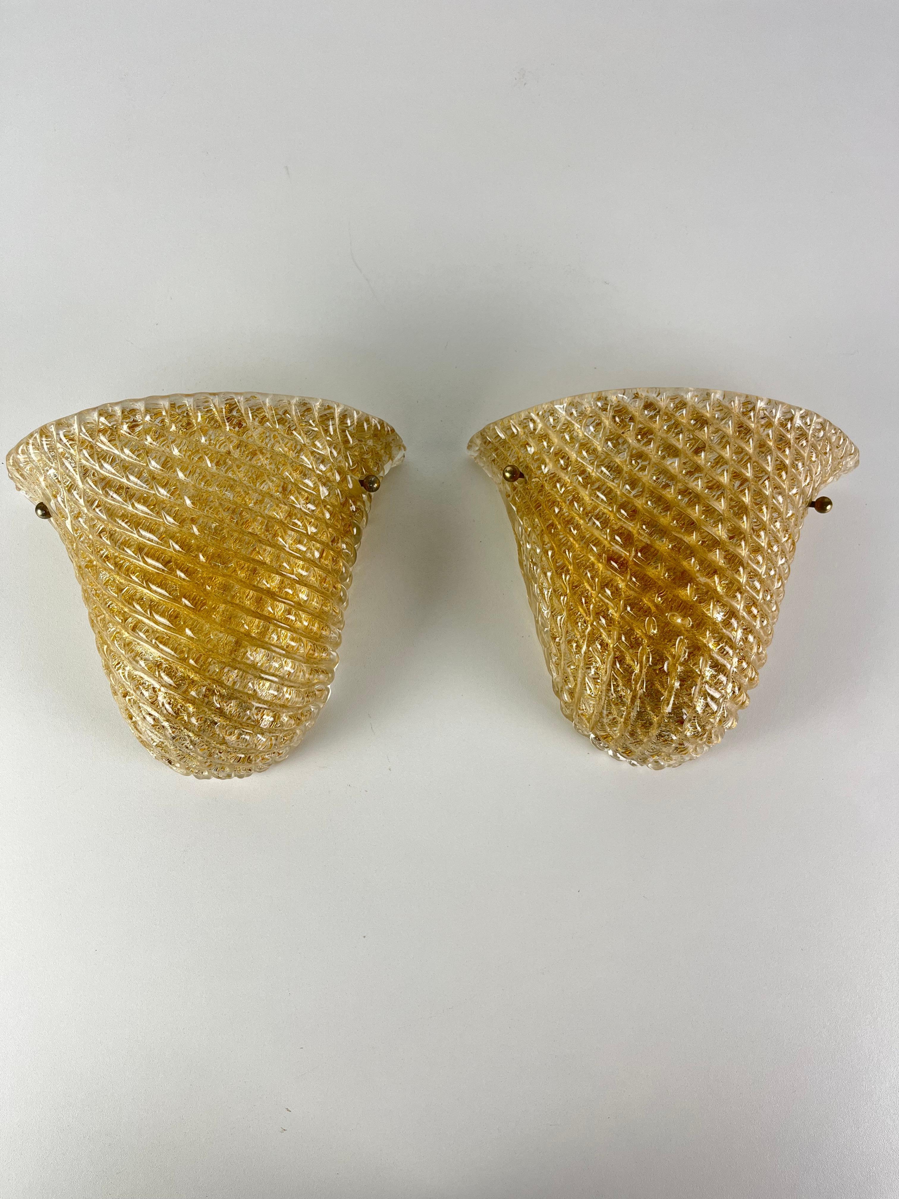 Juego de 2 apliques venecianos en cristal rostrato de Murano atribuidos a Venini, años 50
Color transparente y dorado, cristal intacto, estructura metálica, lámparas e14.
Buen estado.

Envío rápido y asegurado con embalaje adecuado y mensajería DHL