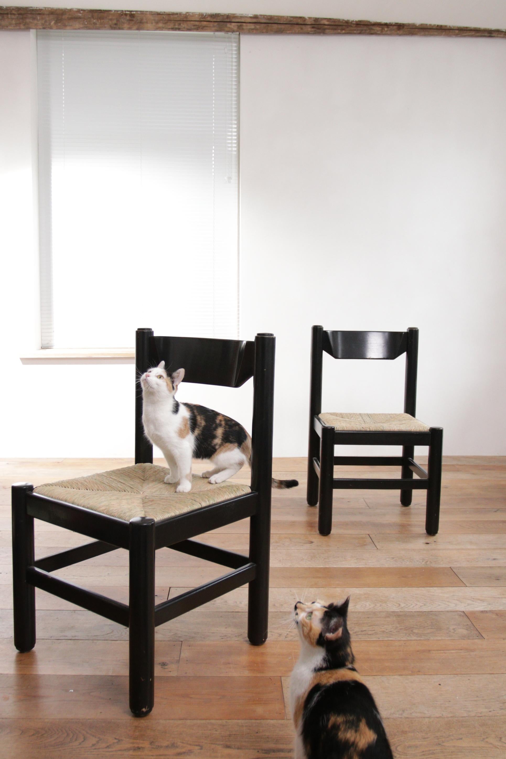 Beautiful design dining room chairs dating from the ‘70s.
These chairs are often attributed to Vico Magistretti, produced by Cassina, made in Italy. 
Made of solid black coated wood. The seats are made of new rush.


