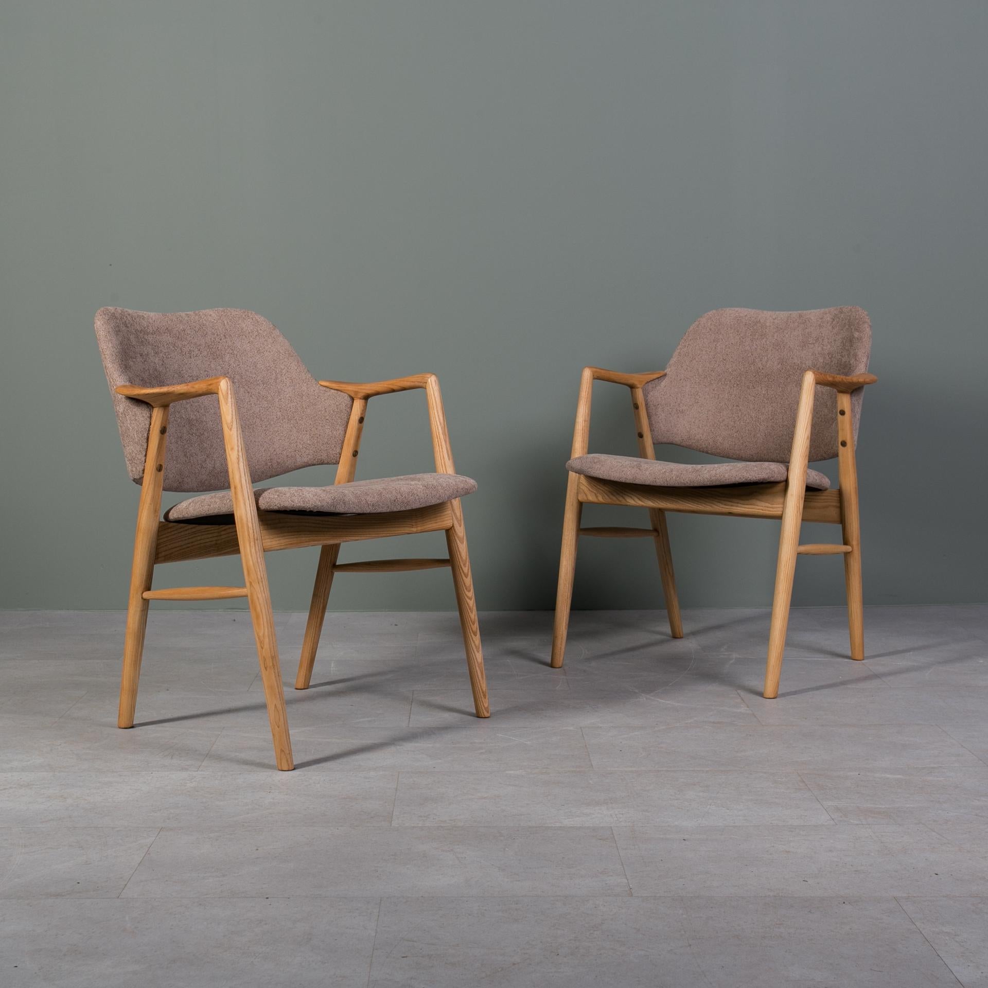 Questo set di 2 sedie proviene dalla Norvegia ed è stato realizzato intorno agli anni '60. Le sedie sono realizzate in legno di frassino e le sedute e gli schienali sono tappezzati. Gli elementi in legno sono stati puliti e rifiniti con olio, che ha