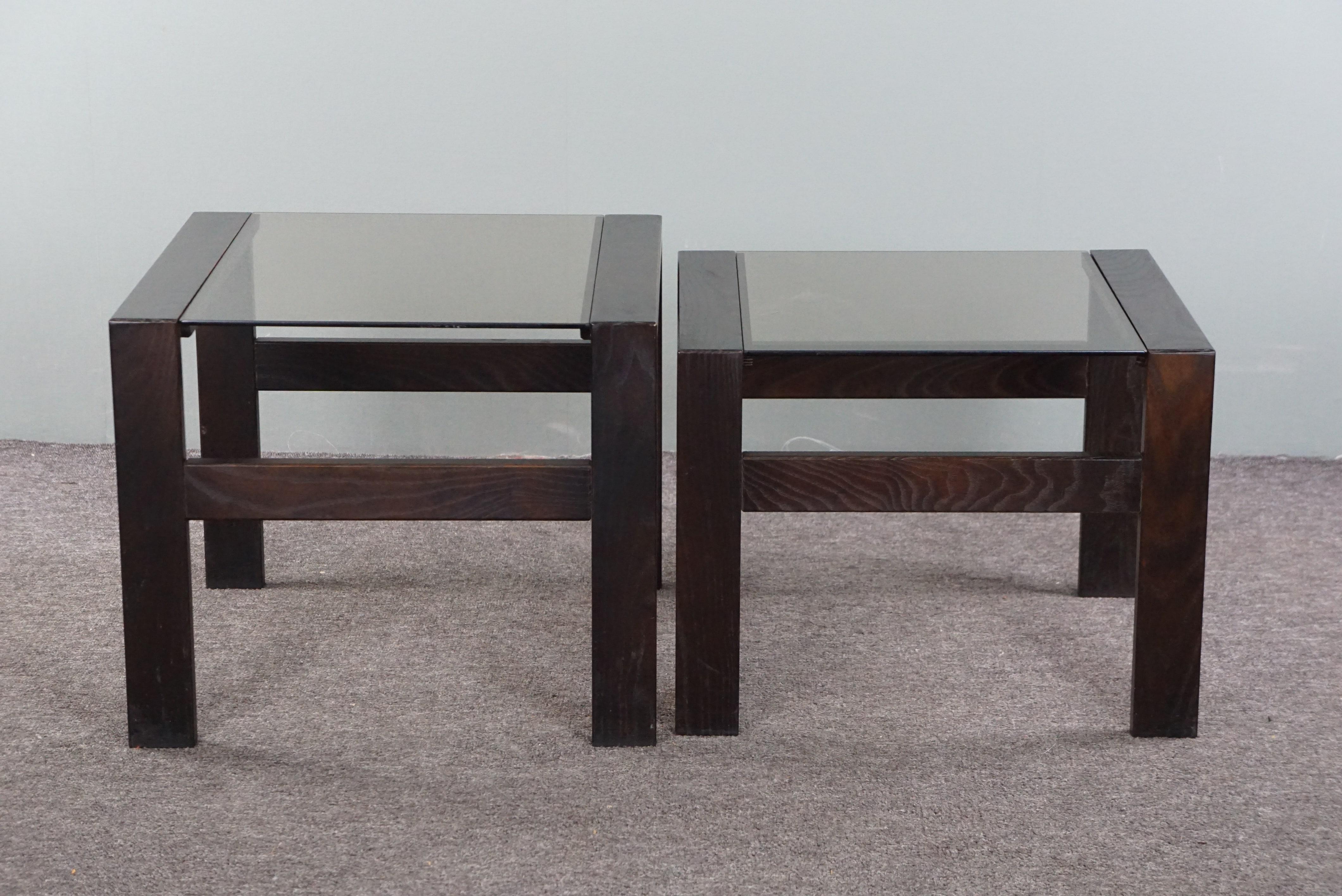 Offered is this charming set of 2 vintage coffee tables or side tables from the 1970s, made of wood and glass. This delightful set is in a good condition and adds a playful touch to your interior. Great for use as a coffee table but also as a side