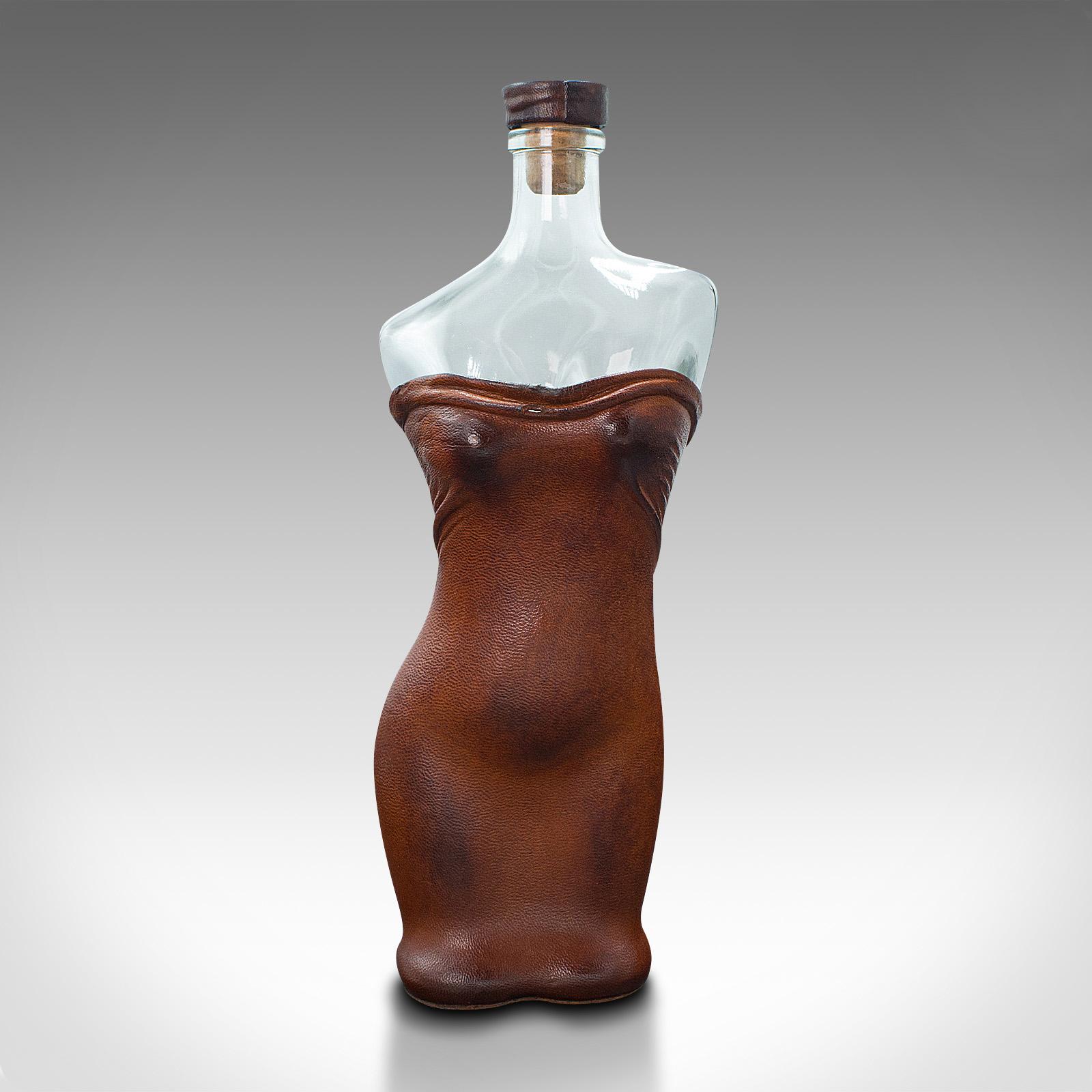 This is a set of two vintage couture spirit bottles. A French, glass and leather wine vessel in the female form, dating to the early 20th century, circa 1930.

Delightfully feminine, with fascinating leather dressings
Displaying a desirable aged