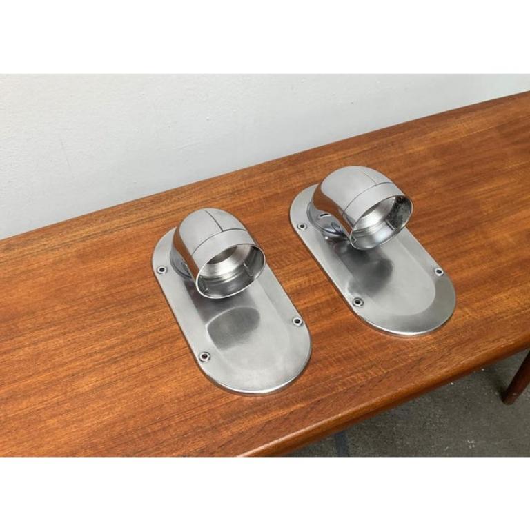 Apliques sencillos del fabricante danés Nordisk Solar según un diseño de Ole Pless Jørgensen de los años 70.

El cuerpo de la luminaria, de aluminio, es de gran calidad. De la placa de pared maciza sale un tubo acodado. El tubo está abierto en la