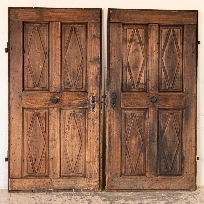 The diamond panels and old hardware create a strong vintage look in this set of 2 doors, which may serve well as pantry door, wine cellar door or for a popular sliding barn door look in today's modern home. The diamond relief in the four panels is