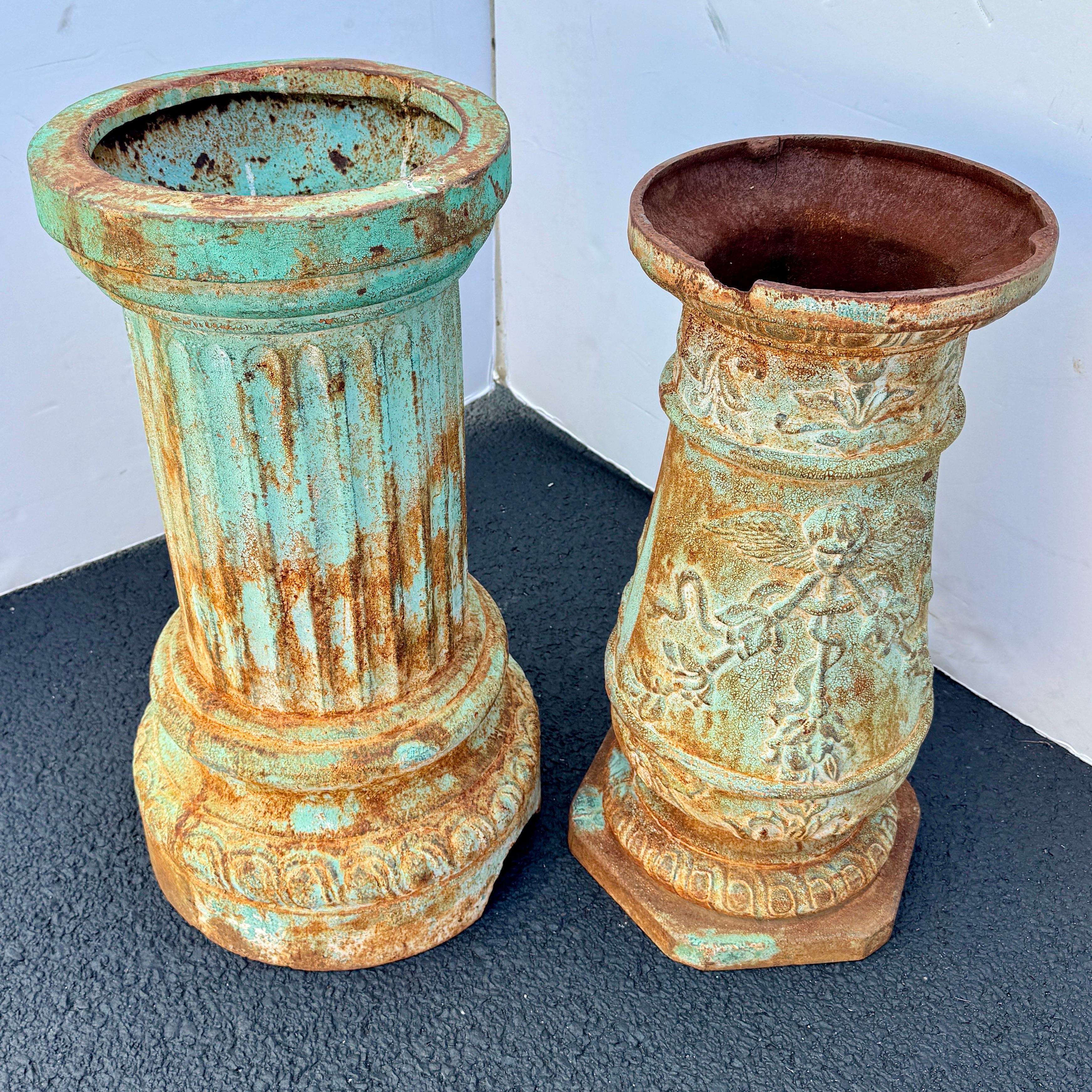 Questi straordinari piedistalli in ghisa dei primi del '900, provenienti dalla Francia settentrionale o dal Belgio, rivelano una sottile patina verde sotto la loro superficie. Un pezzo è ornato da affascinanti angeli e intricate ghirlande floreali,