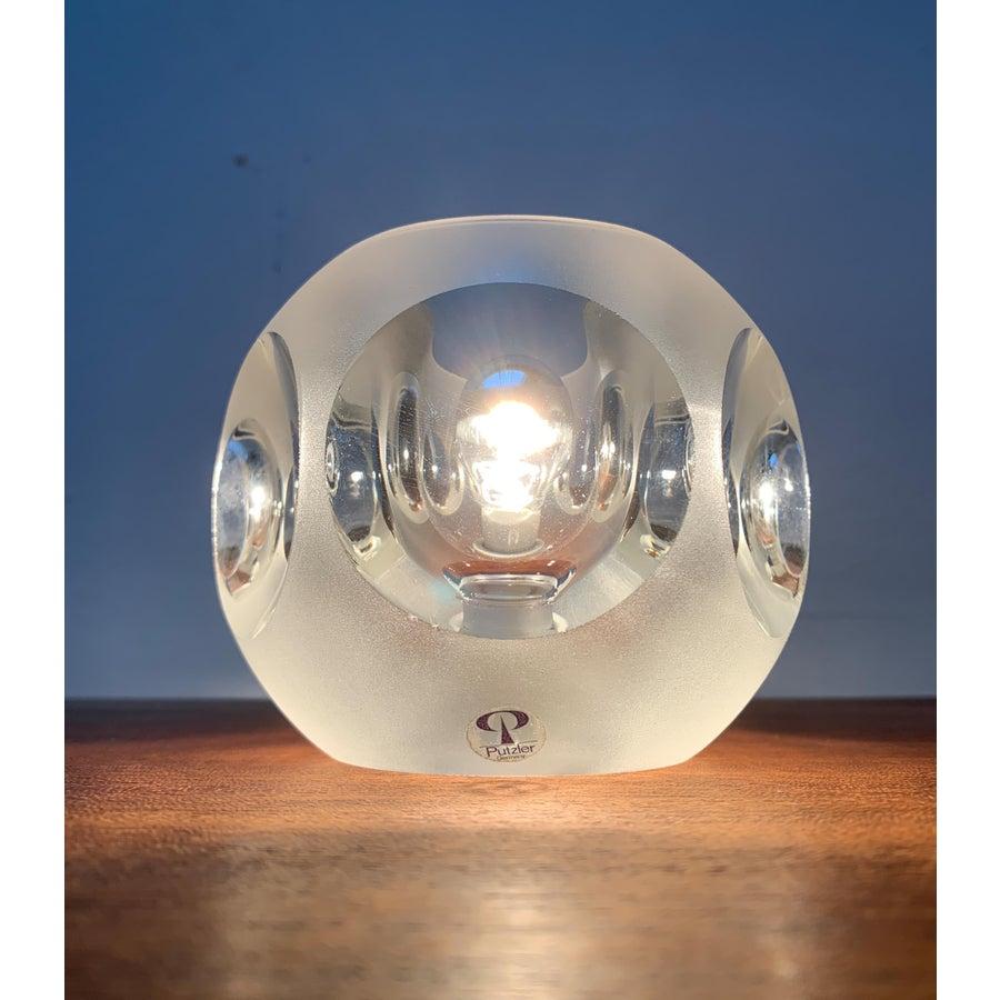 Lampade da tavolo in vetro del rinomato produttore Peill & Putzler.

Il corpo esagonale della lampada è realizzato in vetro spesso. Le superfici laterali sono concave e rientranti. Gli incavi sono chiari. Il materiale rifrange e diffonde la luce e