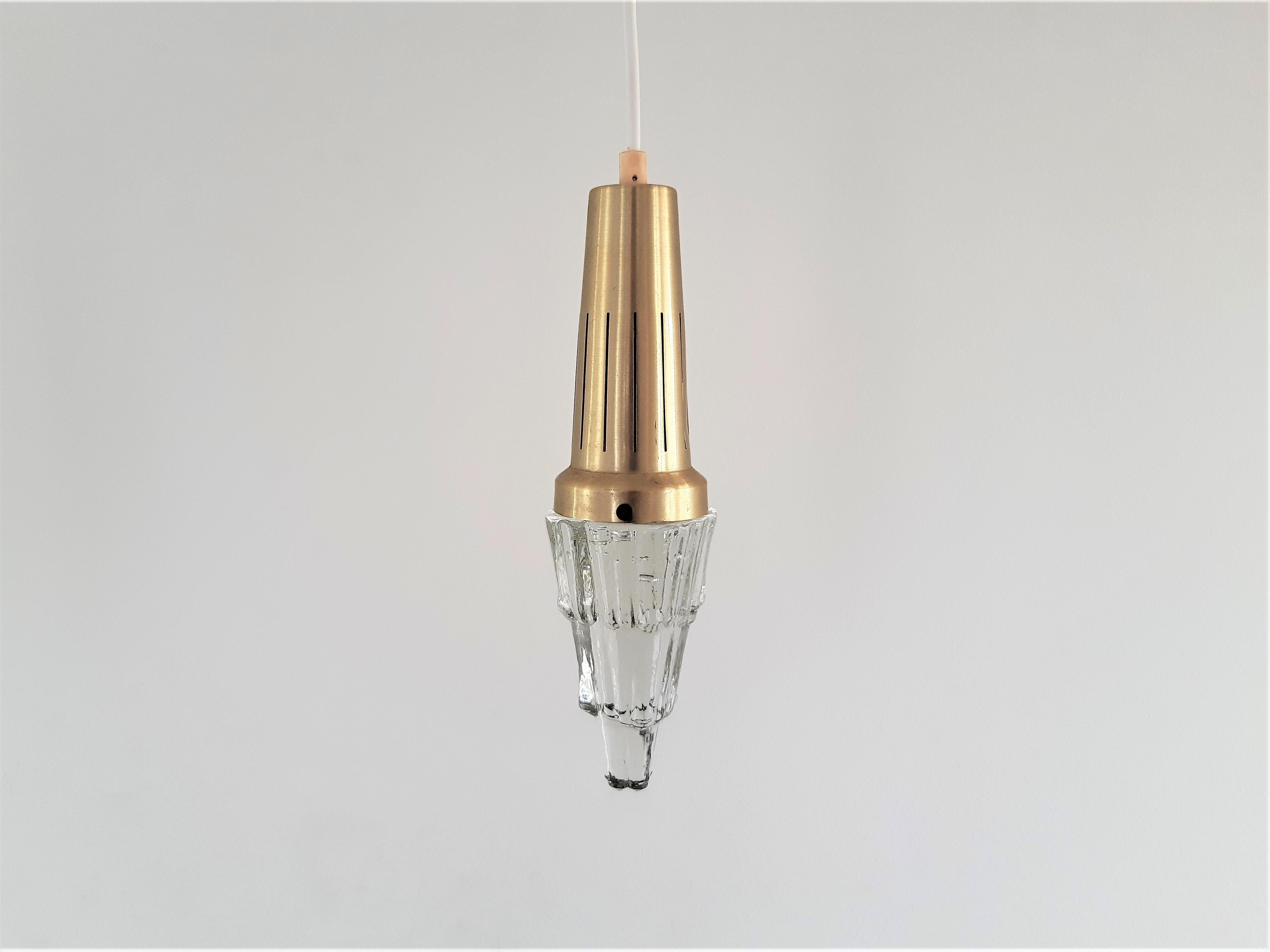 This is a very decorative set of 2 pendant lamps that have the shape of an icicle. It was designed for Vitrika in Denmark. They have a light brass colored aluminum fixture with a thick and heavy pressed glass. Together it gives a very nice light