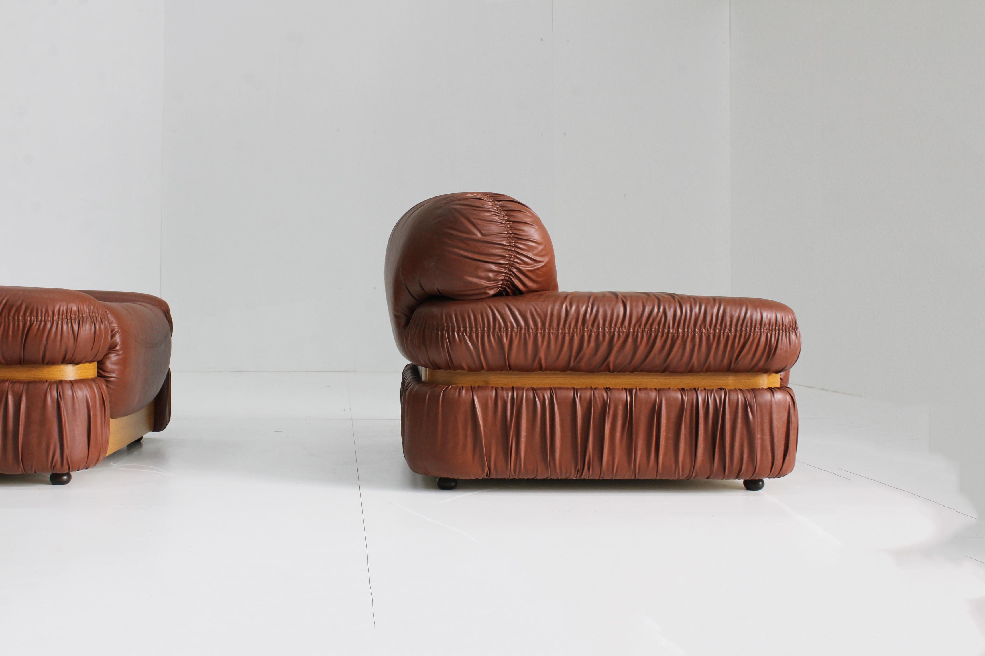 Set of 2 vintage Italian armchairs beautifully designed from the 1970s. These comfy chairs are in a very good condition with minor traces of use.
Cognac faux leather with wooden details.