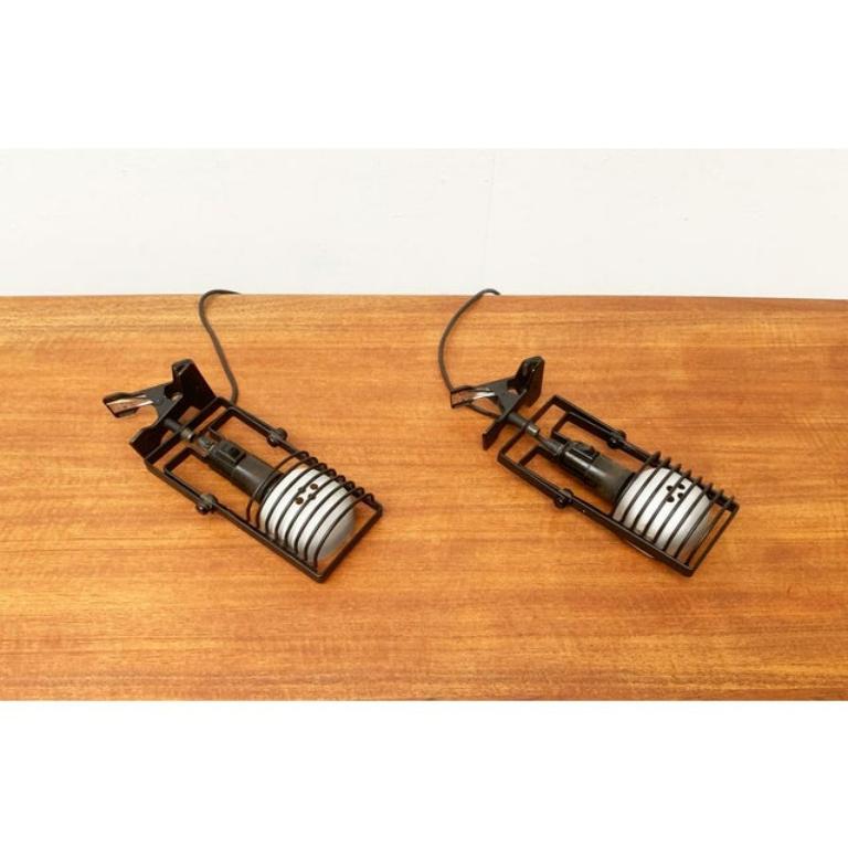 Rares lampes à pince de la série Sintesi du fabricant italien Artemide d'après un design d'Ernesto Gismondi des années 70.

Les lampes présentent les éléments caractéristiques de la série Sintesi, les montants noirs et le cadre fin avec joint. La