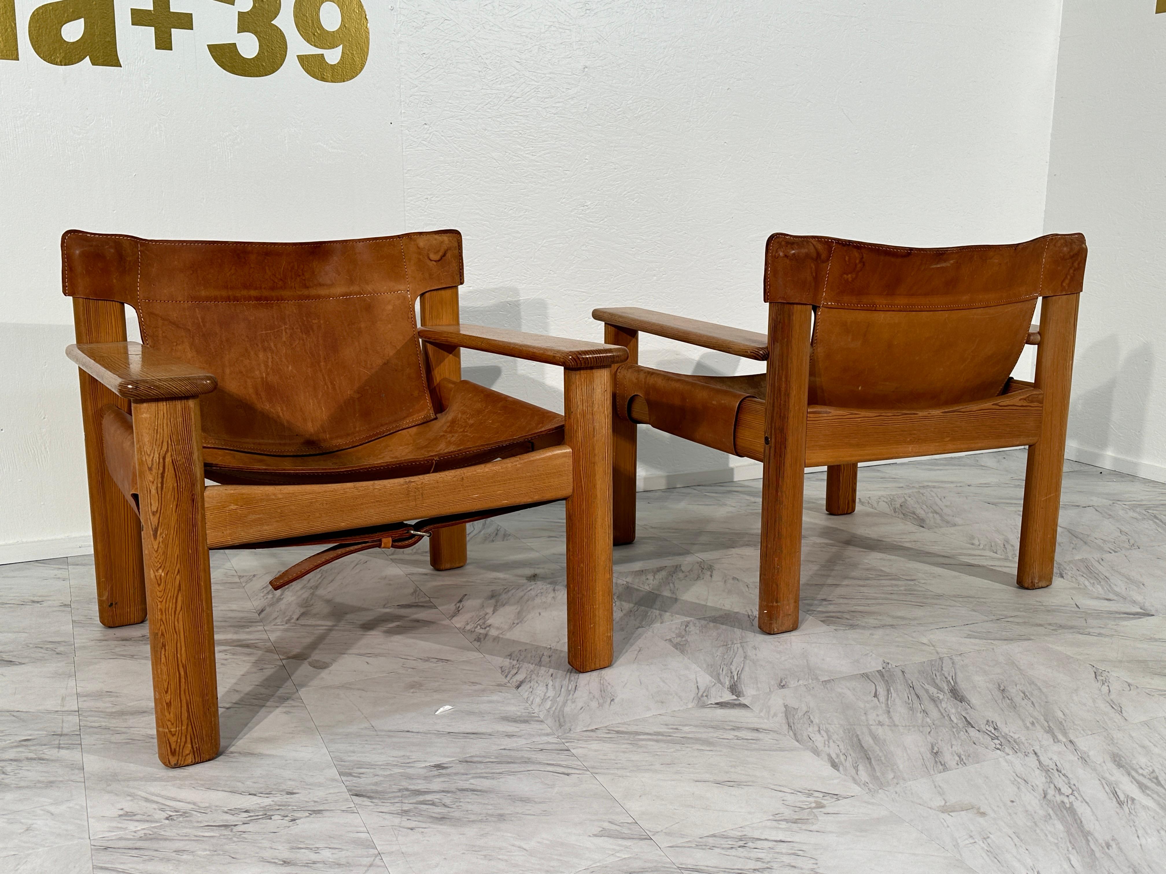 The Set of 2 Vintage Italian Wood and Leather Safari Chairs from the 1970s epitomizes the adventurous spirit of safari expeditions while exuding timeless elegance. Crafted in Italy during the 1970s, these chairs feature sturdy wooden frames