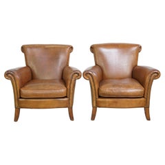 Conjunto de 2 sillones vintage de piel de oveja, acabados con cabezas de clavos decorativas