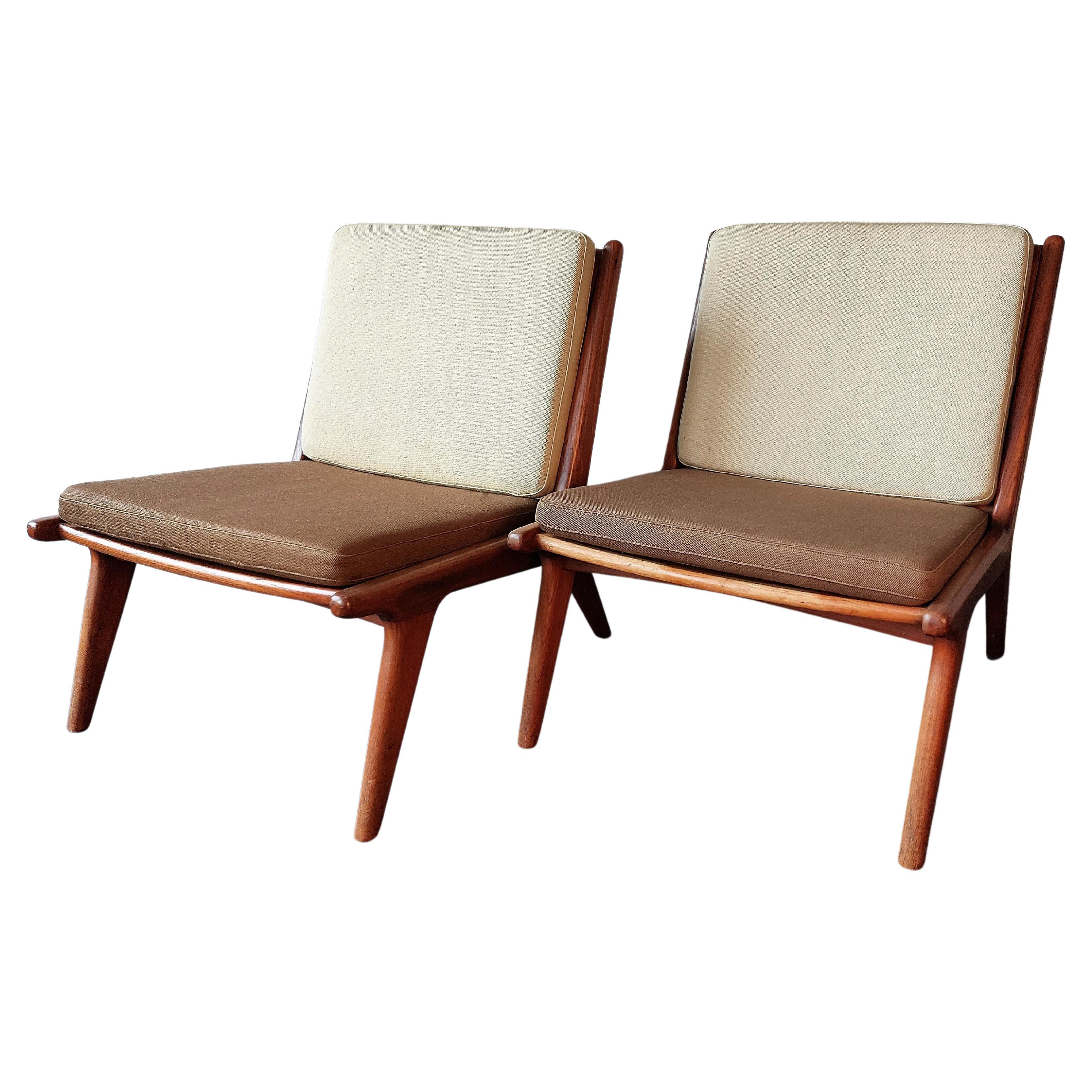 A beautiful set of 2 vintage lounge or slipper chairs, most likely made in Denmark. The chairs have a minimalist wooden frame made by fine craftmanship, that is in a good and solid condition. The cushions have their original fabric and the