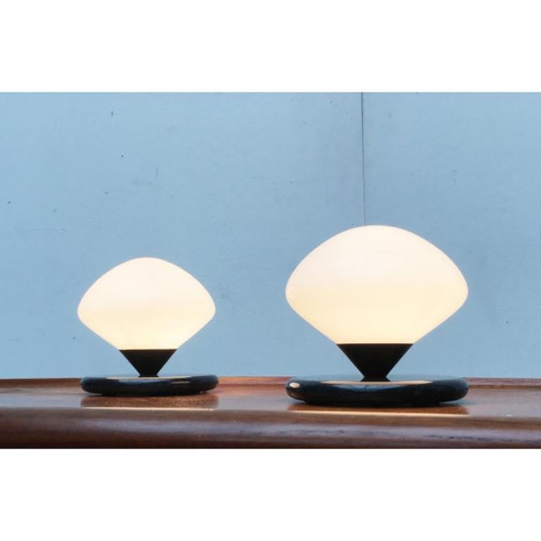 Elegantes lámparas de mesa del fabricante suizo Optelma.

El cuerpo de cristal se equilibraba sobre una pesada base de mármol. El mármol negro está suavemente redondeado en el borde y refleja el receptáculo cónico del vítreo. Esta pieza tiene una