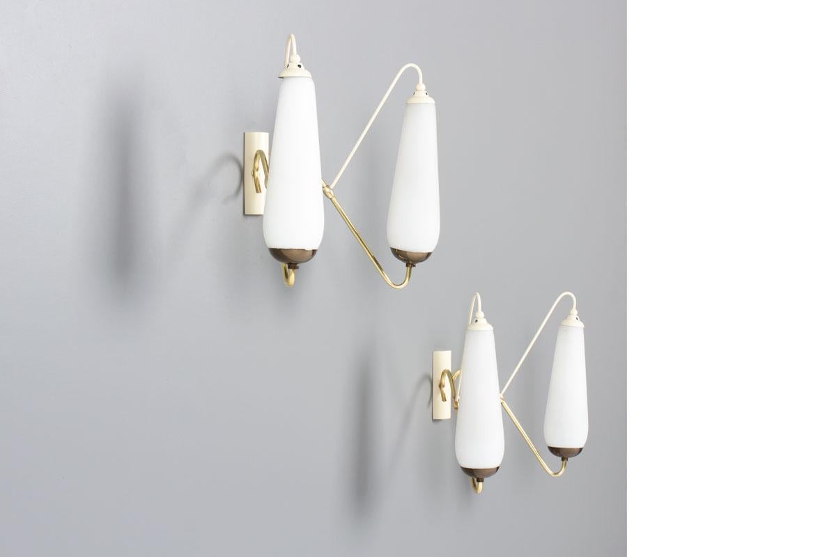 Set di 2 lampade da parete provenienti dall'Italia degli anni '50
Struttura in metallo laccato bianco, ottone e riflettore opalino
2 punti luce per ogni luce
Bella patina del tempo