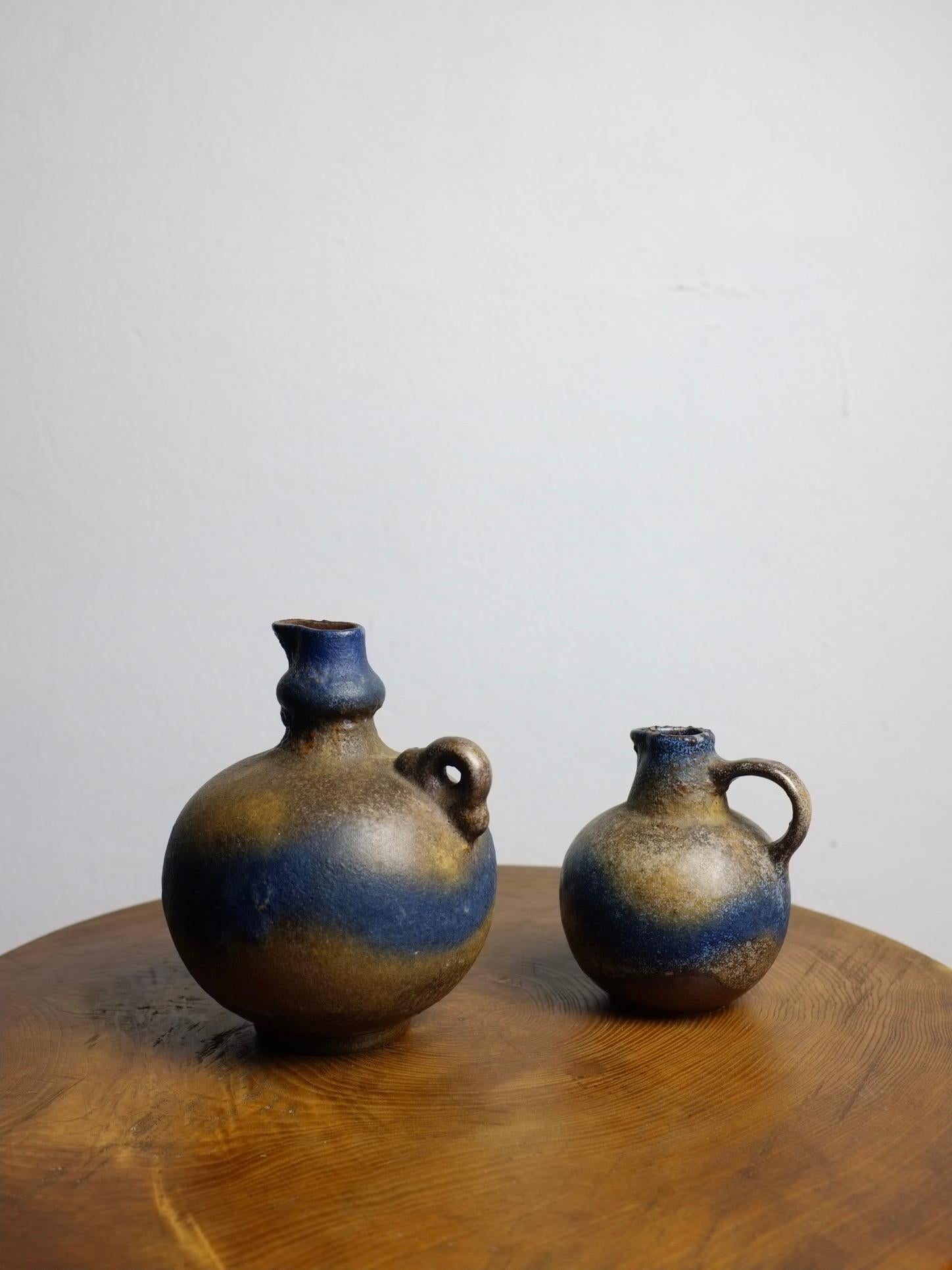 Set of 2 vintage jug vases from Ruscha. Numbered - 304, 308. Beautiful blue-brown glaze.

Additional information:
Country of manufacture: West Germany
Design/Manufacture period: 1960s
Dimensions: Large:  Ø 12 x 16 H cm 
Small: Ø 9 x 11.5 H