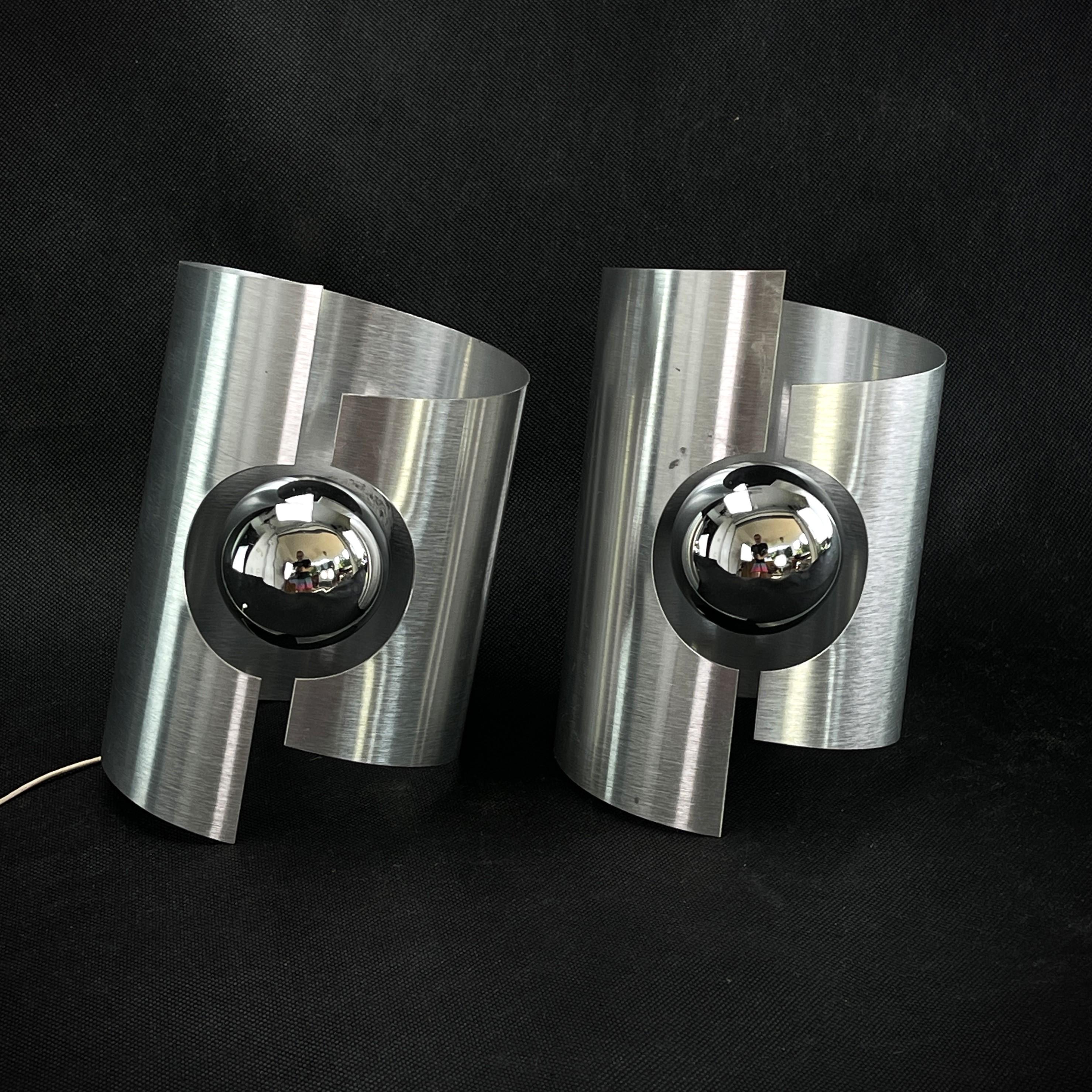 Set of 2 x Aluminium Wall Lamps - 1970s

These great lamps are a real design classic from the 1960s-1970s. The wall lamps are an original of their time and provide a pleasant light. 
Overall, these two, silver lamps are a beautiful and timeless