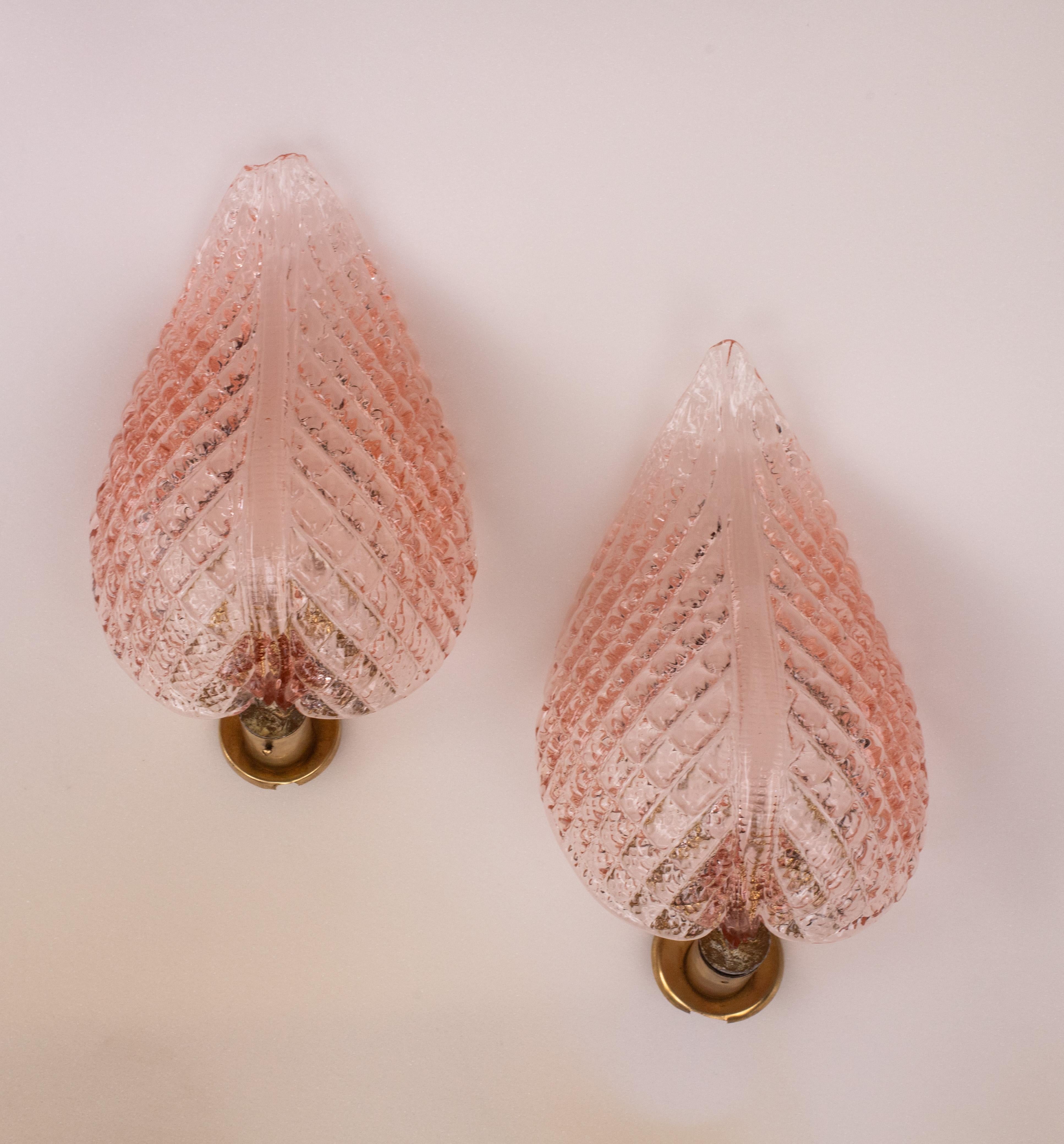 Stunning set of 2 Murano wall light by artist Ercole Barovier with rare pink glass.
The wall light consist of a glass leave and a brass structure.
It mounts a European standard e14 lamp, possible to switch for Usa.
It measures 25 centimetres in