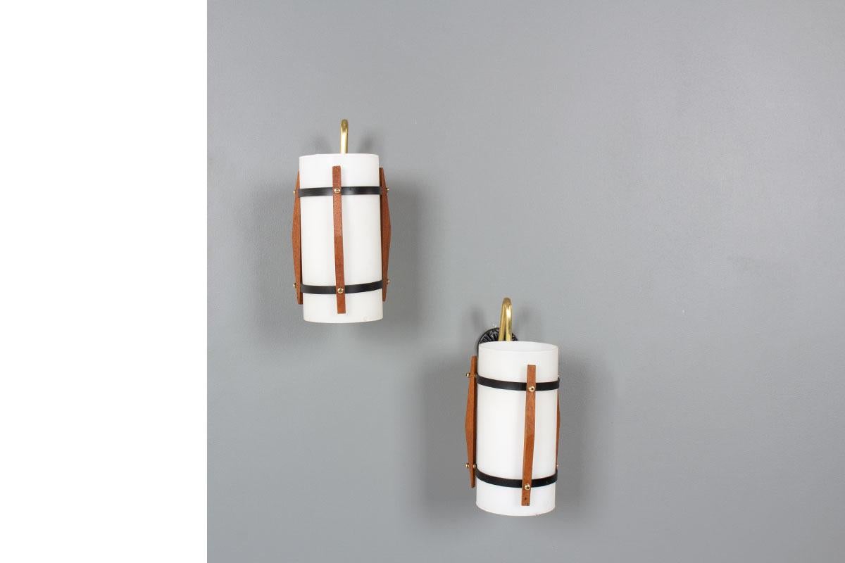 Set di 2 lampade da parete realizzate negli anni '50
Supporto da parete in metallo laccato nero, teak ed elementi in ottone. 
Riflettore in vetro opalino.
2 lampadine E14
Bel design