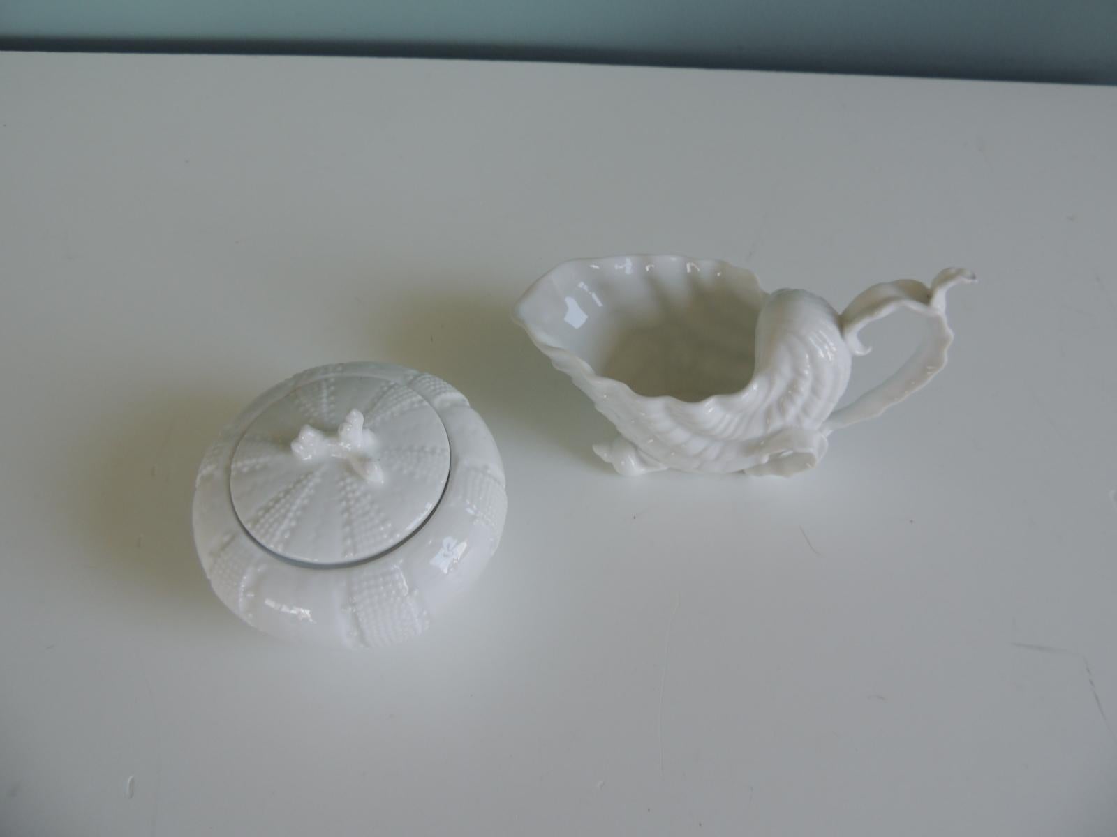 Set of (2) white Nautical Theme Vintage creamer & sugar holders/serving pieces
In the shapes of an urchin and a nautilus seashell creamer
Sizes: Urchin is 4
