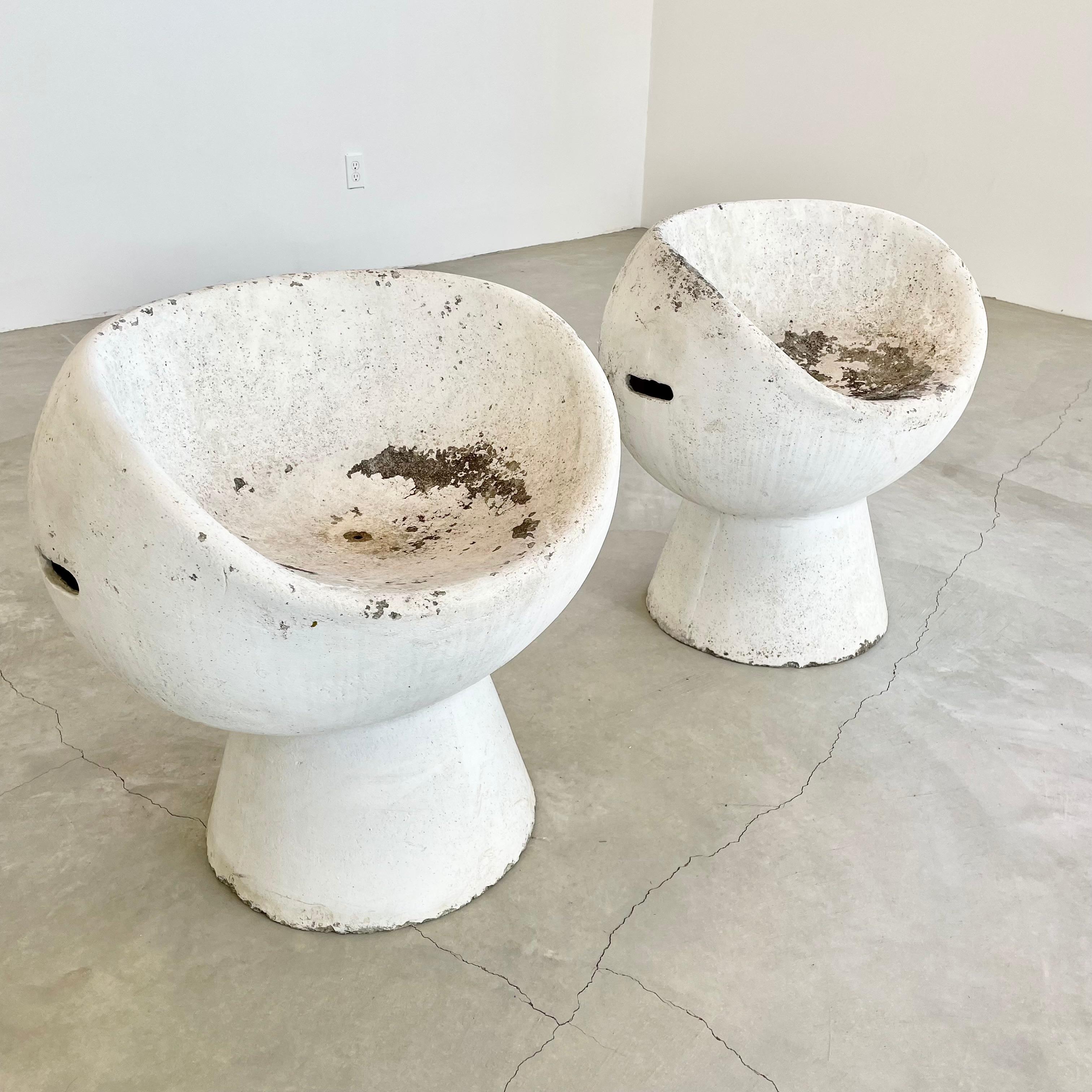 Stunning set of two concrete pod chairs designed by Swiss Architect Willy Guhl. Hand made in Switzerland by Eternit in the 1960s. Excellent patina. Factory drilled hole for water to drain. Great sculptural pieces. Perfect for indoors or outside.