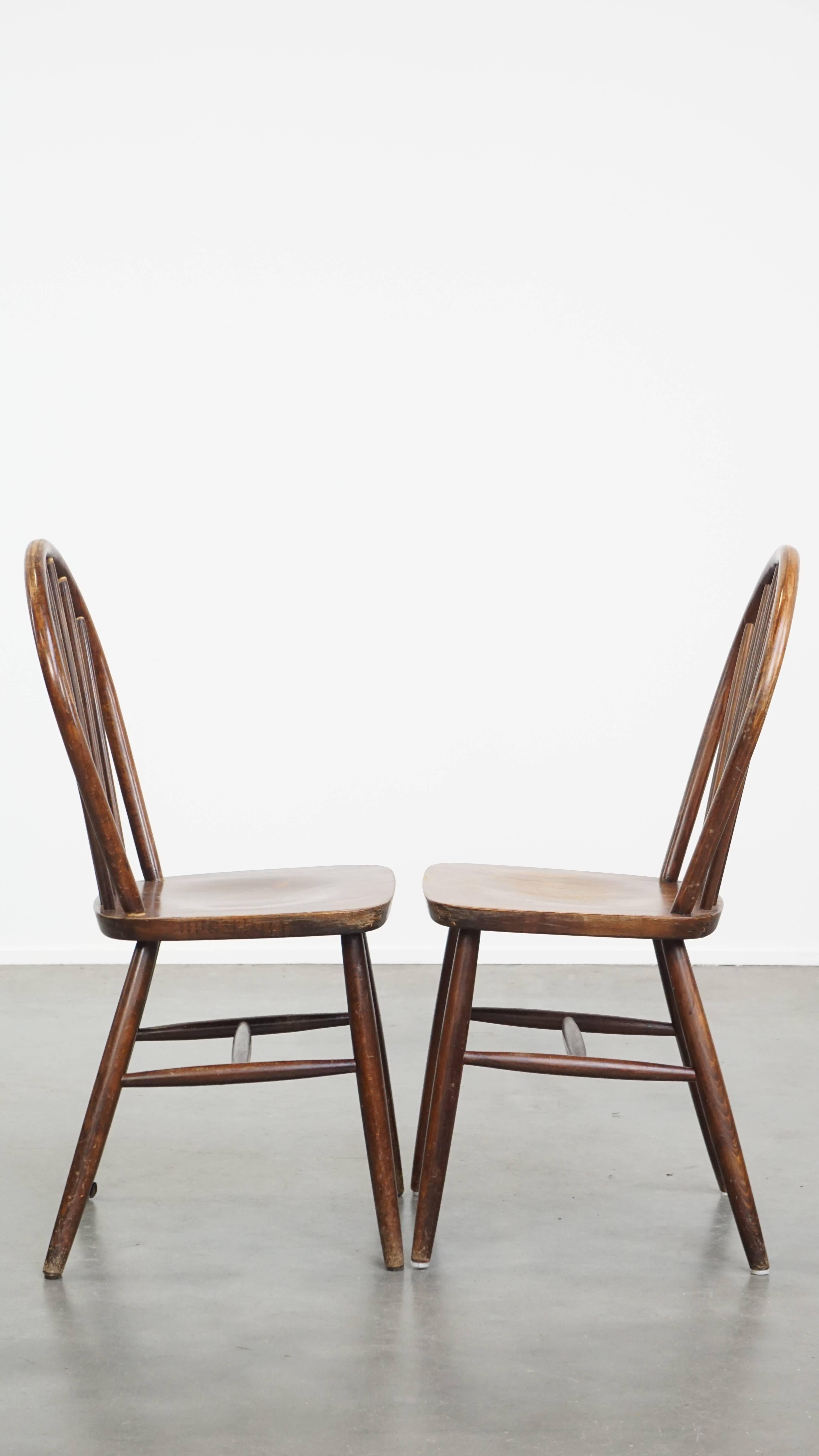 Offered this set of 2 wooden vintage Windsor slat chairs from the 70s in English style.

These great vintage wooden slat chairs from the 70s in English style are not only good to use in a home environment, but also in the catering industry or an