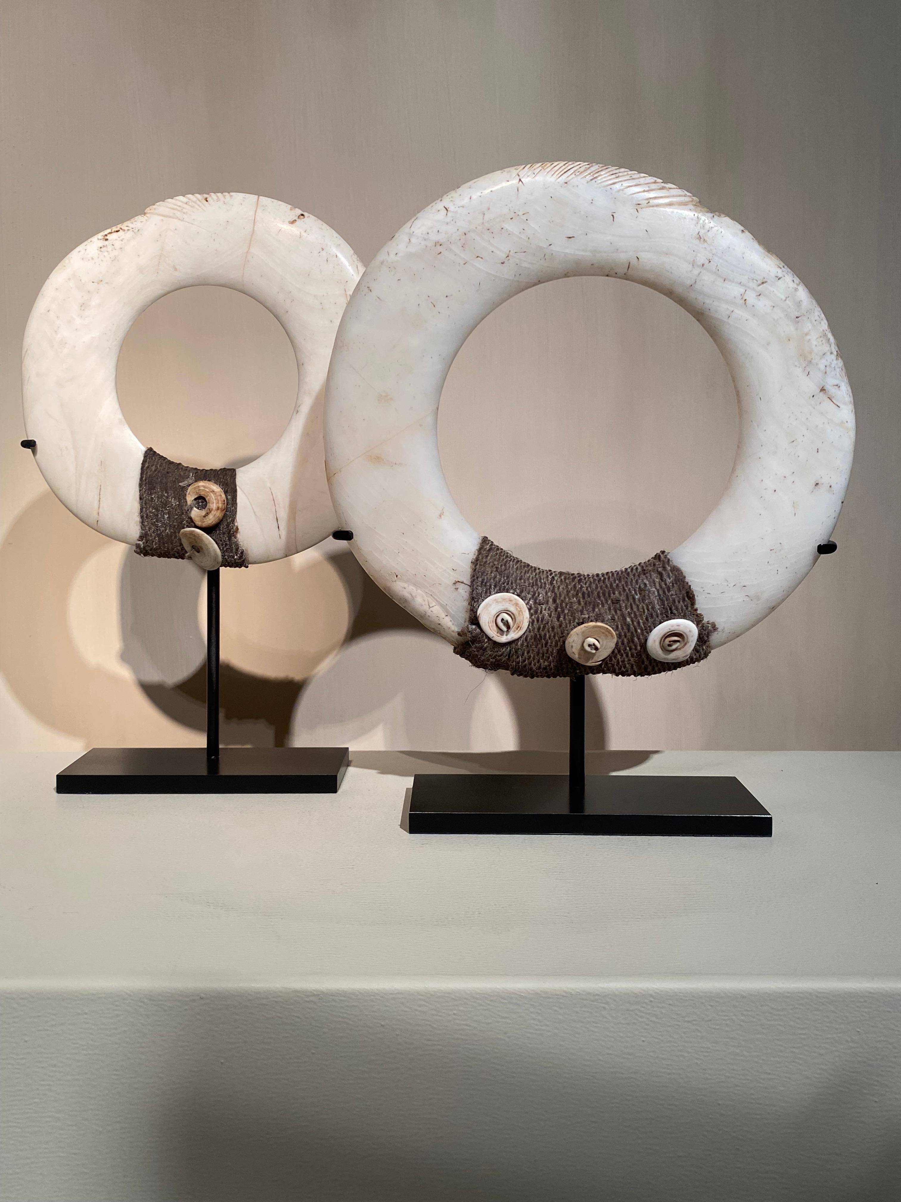 Conjunto de 2 Anillos Yua en Concha de Papúa Nueva Guinea, bellamente decorados con fibras y pequeñas conchas y elegantes adornos,
los anillos de concha están hechos y cortados a mano
buena pátina y desgaste de la cáscara,

32 cm de alto x 21 cm de